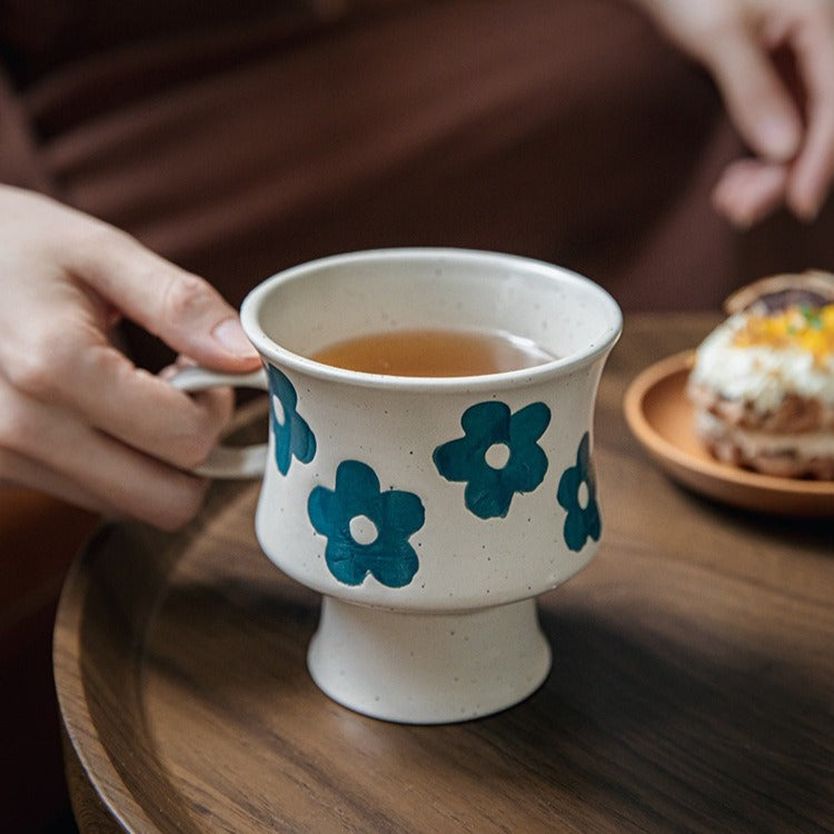 This is a 300ml ceramic goblet mug with hand-painted leaf or flower patterns and a matte sesame-speckled glaze design. With mouth diameter of 9.7, bottom diameter of 6.7cm and height of 10.5cm, this mug is ideal for coffee, milk, water, or oatmeal during slow mornings or quiet afternoons.