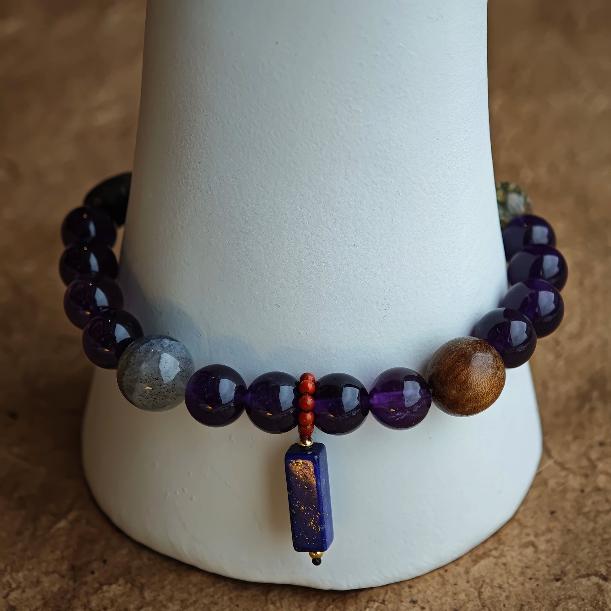 This is a Uruguayan amethyst bracelet comes with amethyst, rutilated quartz, clear quartz and aloeswood. And there is a pendant with lapis lazuli and southern red agate as a decoration.