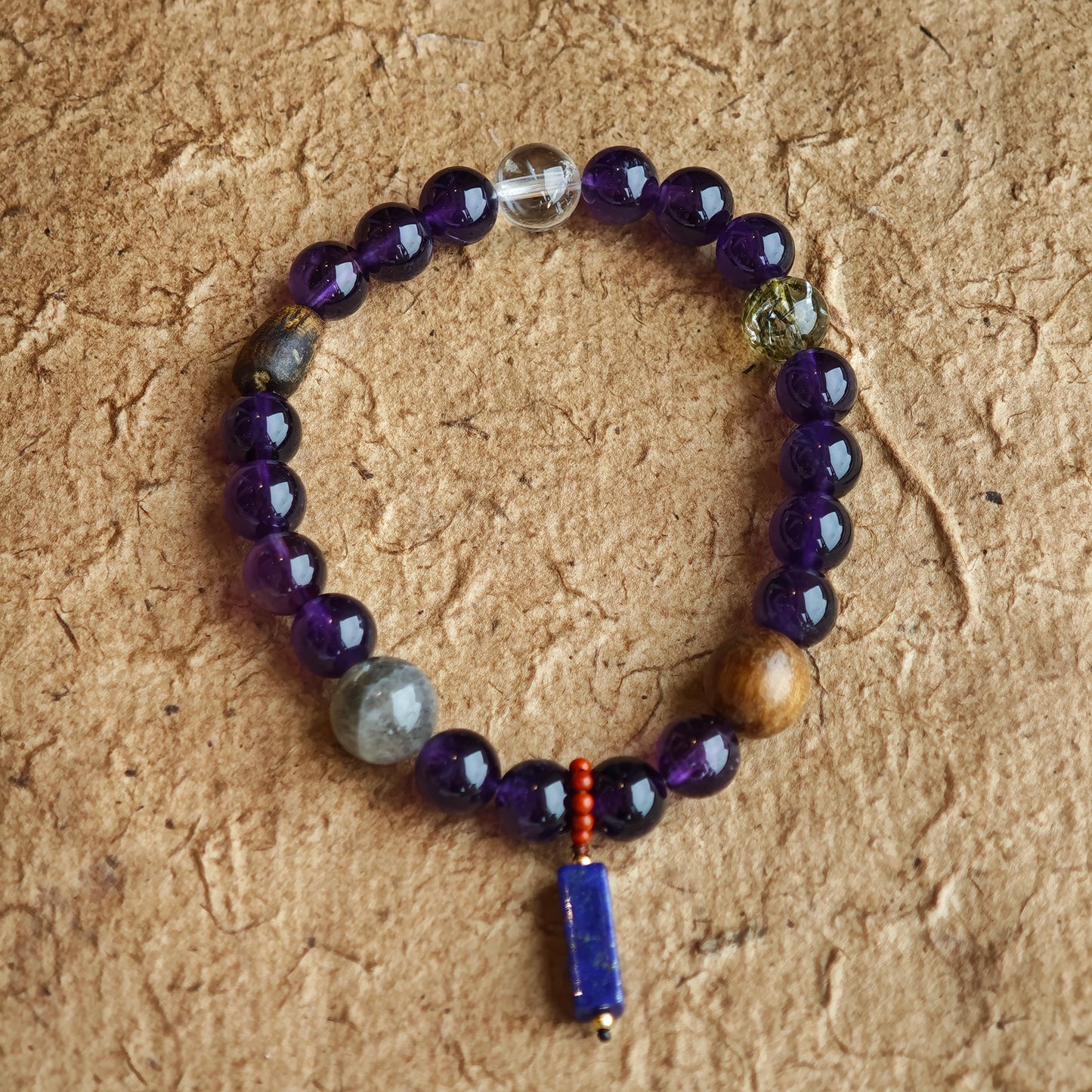 This is a Uruguayan amethyst bracelet comes with amethyst, rutilated quartz, clear quartz and aloeswood. And there is a pendant with lapis lazuli and southern red agate as a decoration.