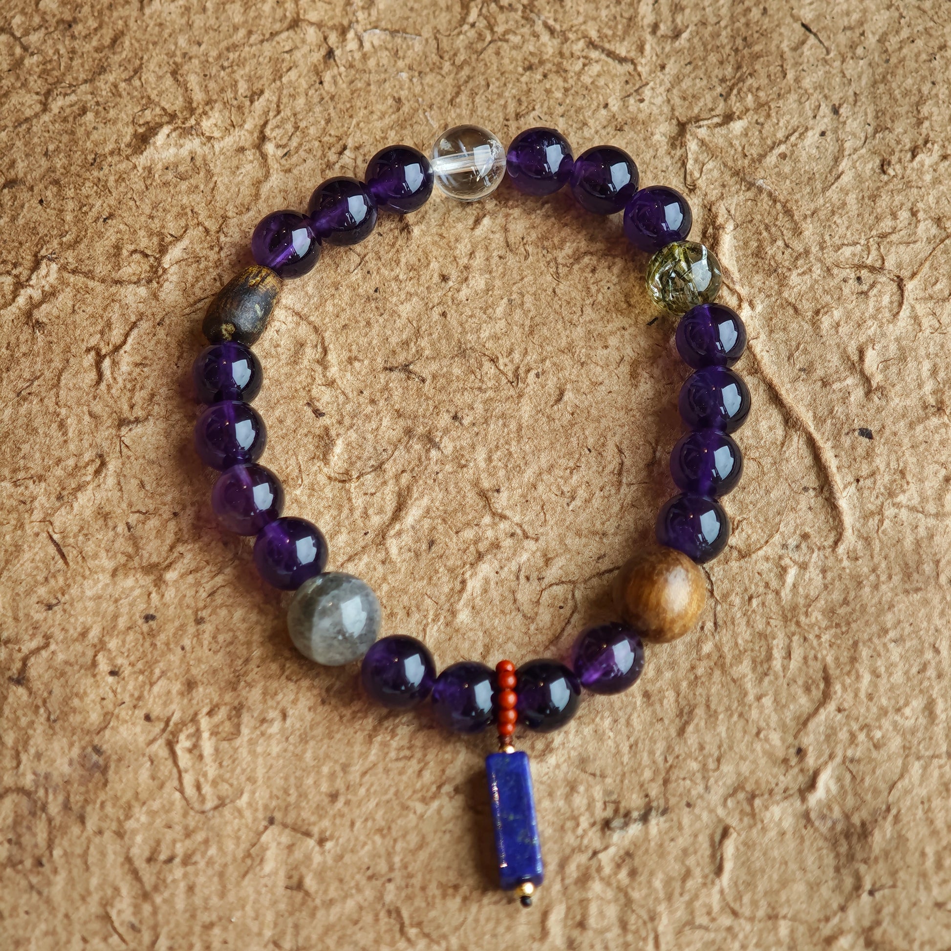 This is a Uruguayan amethyst bracelet comes with amethyst, rutilated quartz, clear quartz and aloeswood. And there is a pendant with lapis lazuli and southern red agate as a decoration.
