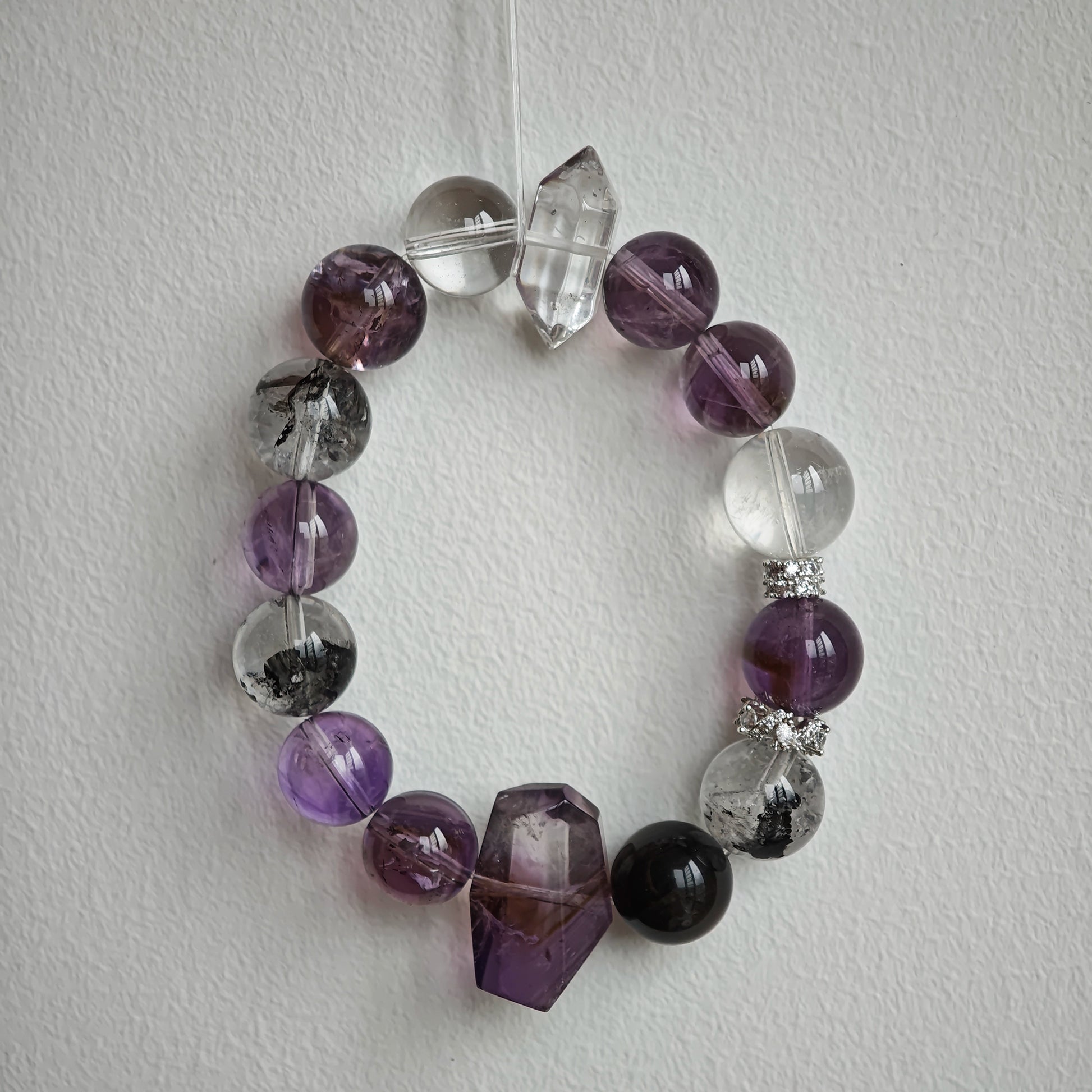 An amethyst bracelet accented with herkimer diamond, clear quartz and silver sheen obsidian.