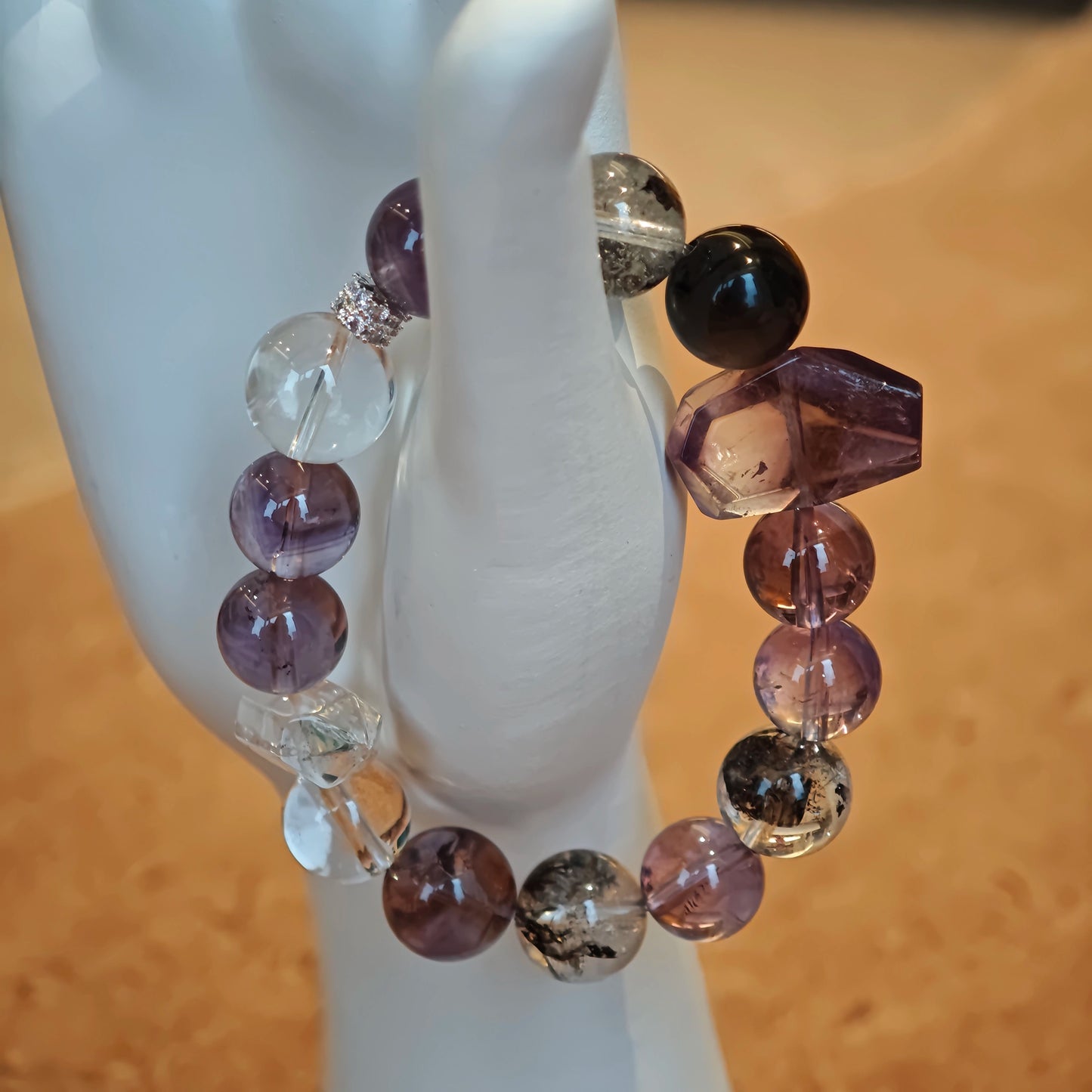 An amethyst bracelet accented with herkimer diamond, clear quartz and silver sheen obsidian.