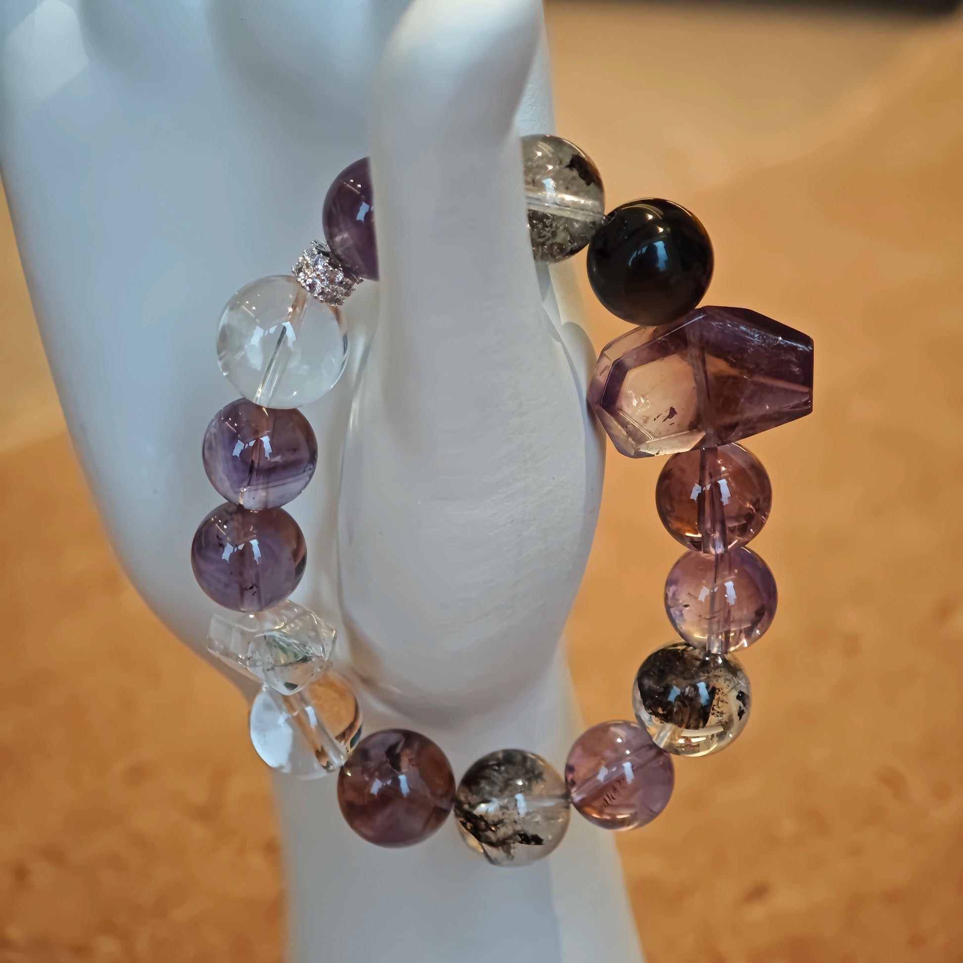 An amethyst bracelet accented with herkimer diamond, clear quartz and silver sheen obsidian.