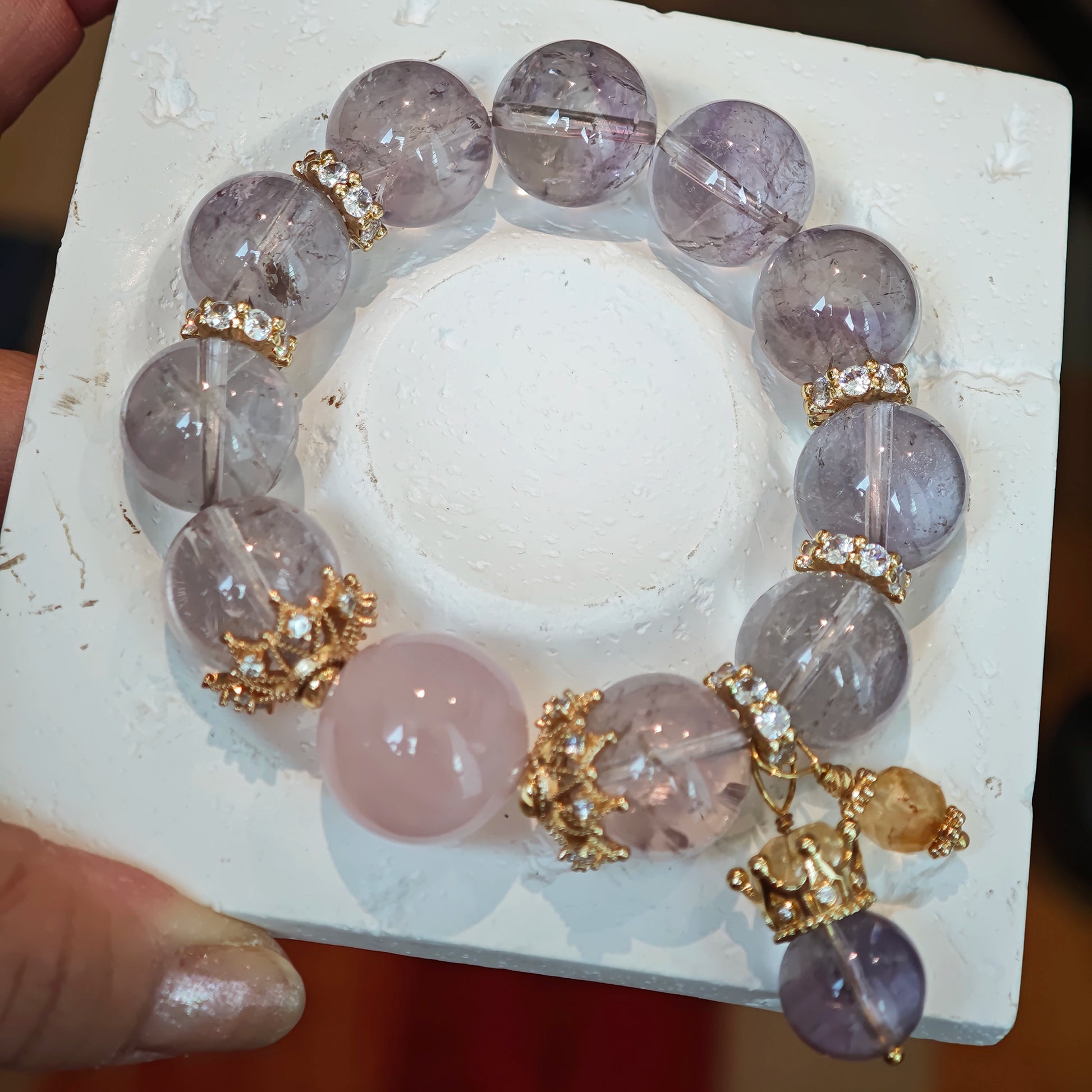 This is a bracelet featuring high-clarity amethyst, rose quartz, and citrine. It's an elegant look of pure peace.