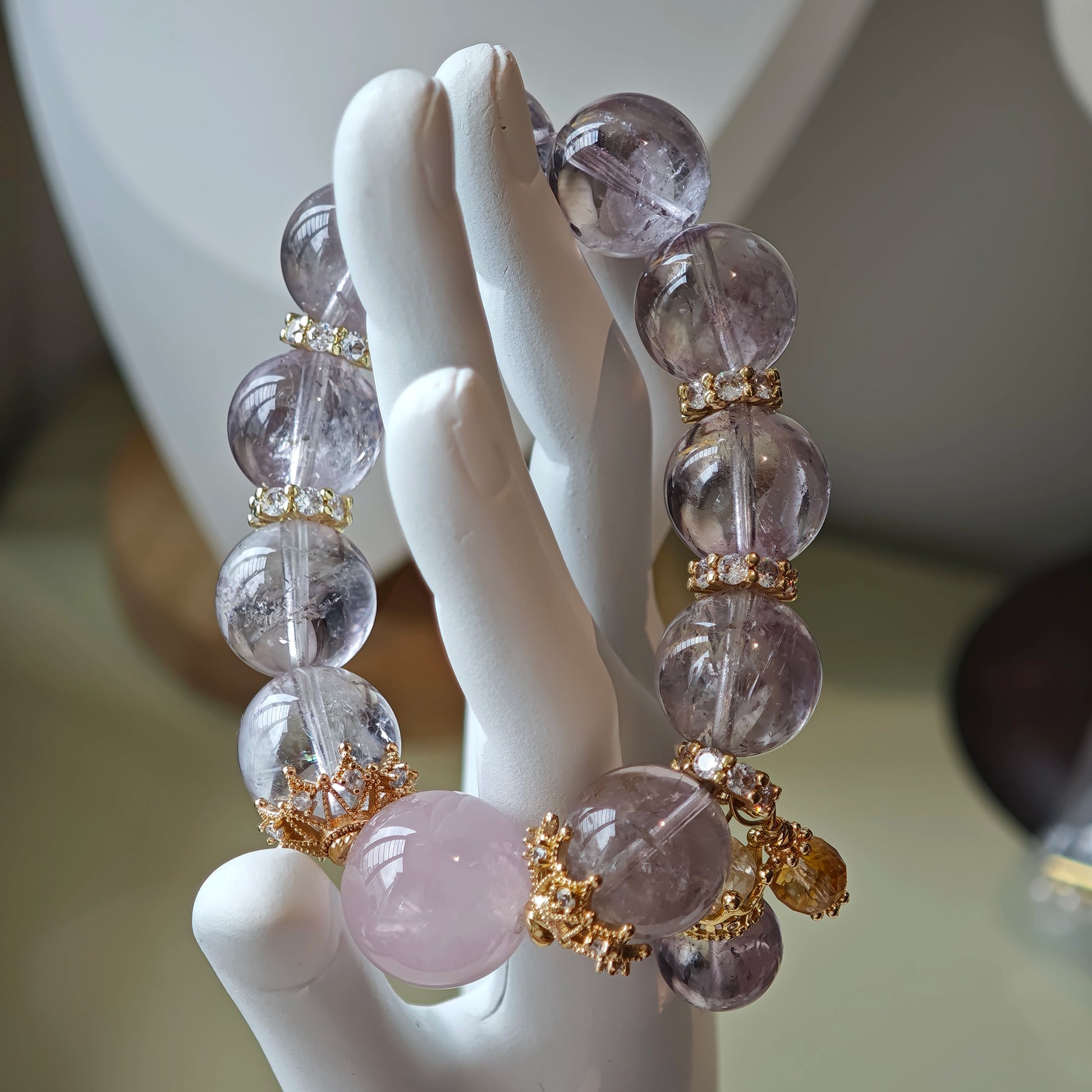 This is a bracelet featuring high-clarity amethyst, rose quartz, and citrine. It's an elegant look of pure peace.