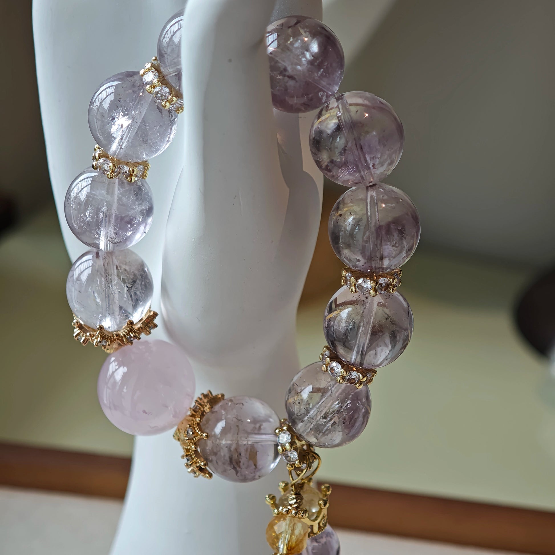 This is a bracelet featuring high-clarity amethyst, rose quartz, and citrine. It's an elegant look of pure peace.