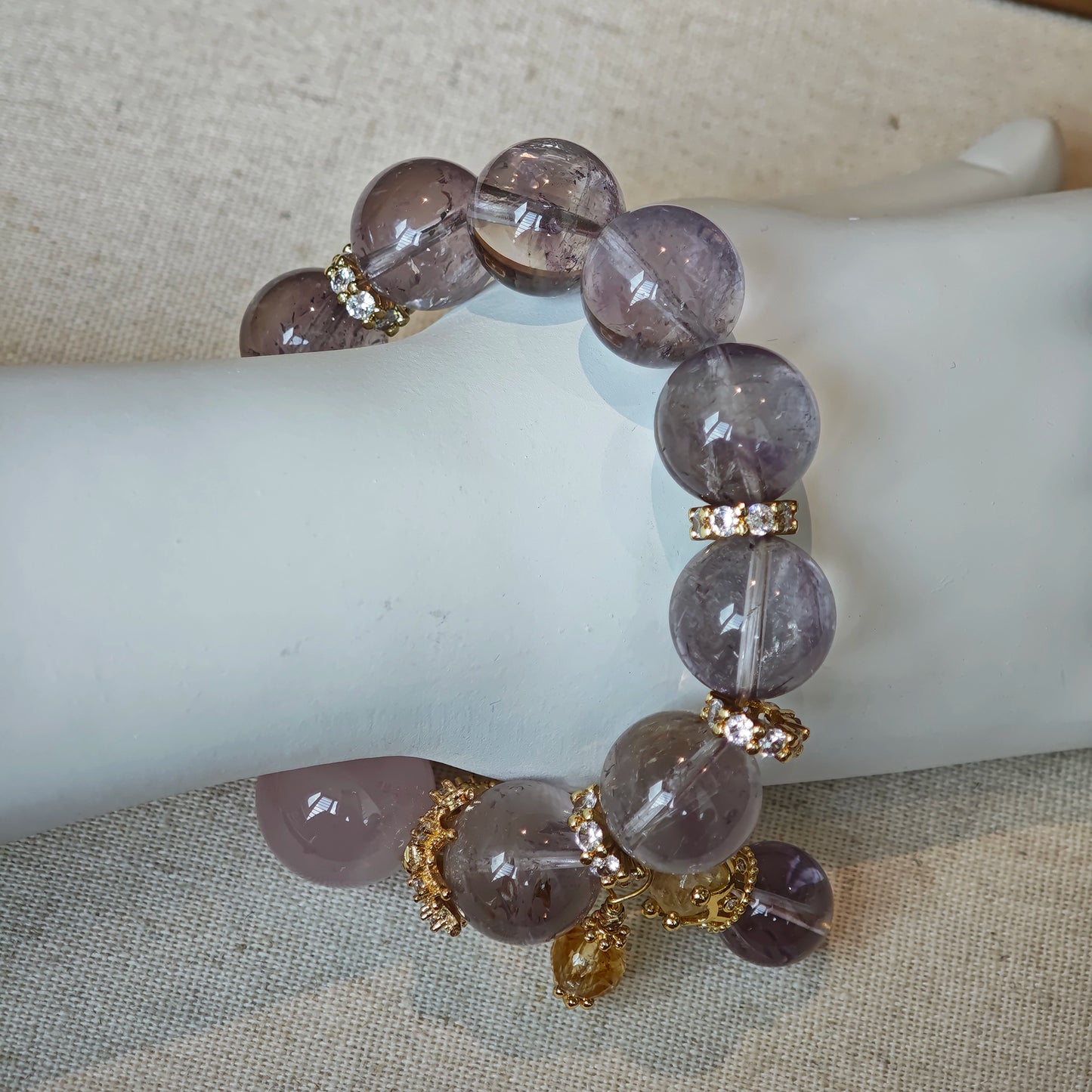 This is a bracelet featuring high-clarity amethyst, rose quartz, and citrine. It's an elegant look of pure peace.