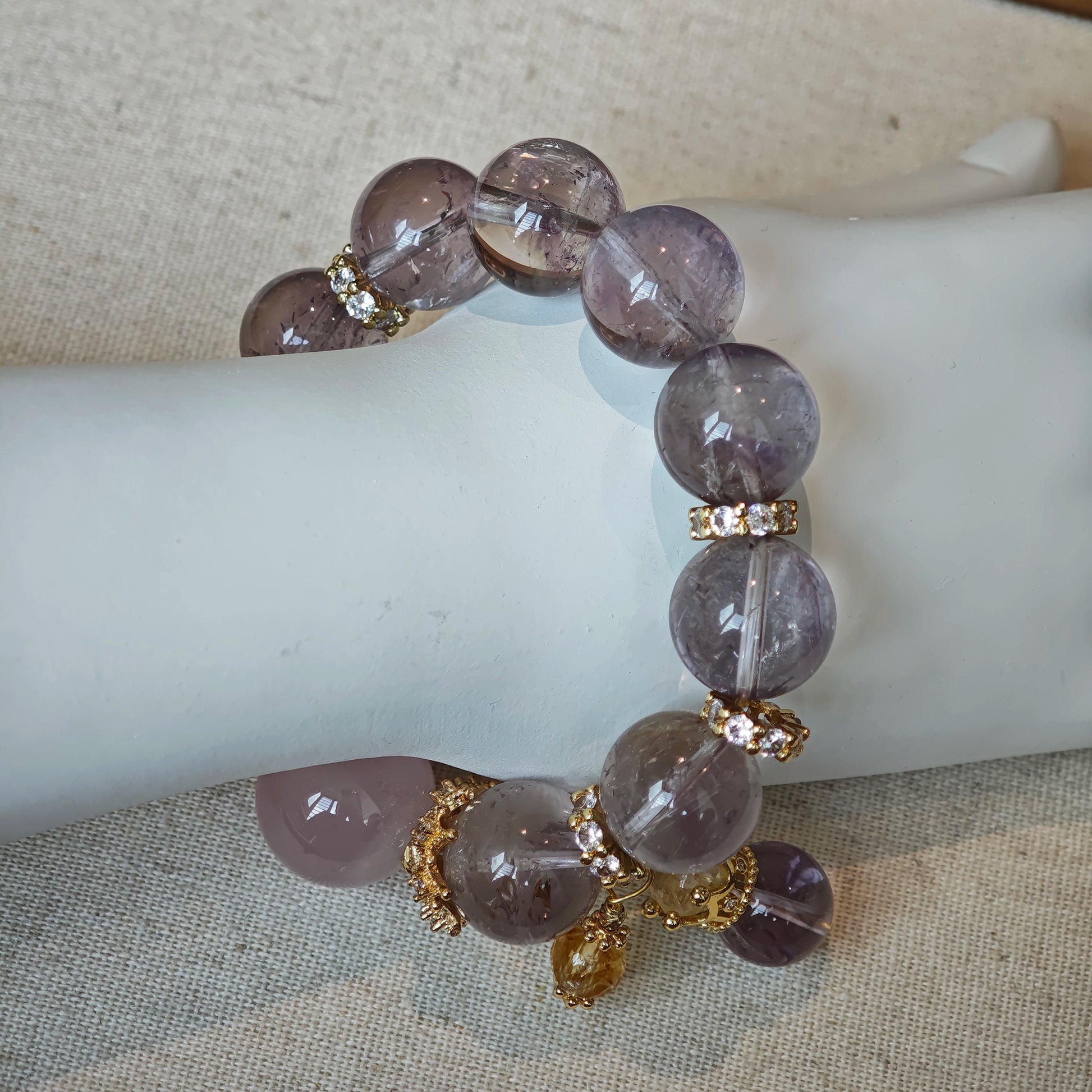 This is a bracelet featuring high-clarity amethyst, rose quartz, and citrine. It's an elegant look of pure peace.
