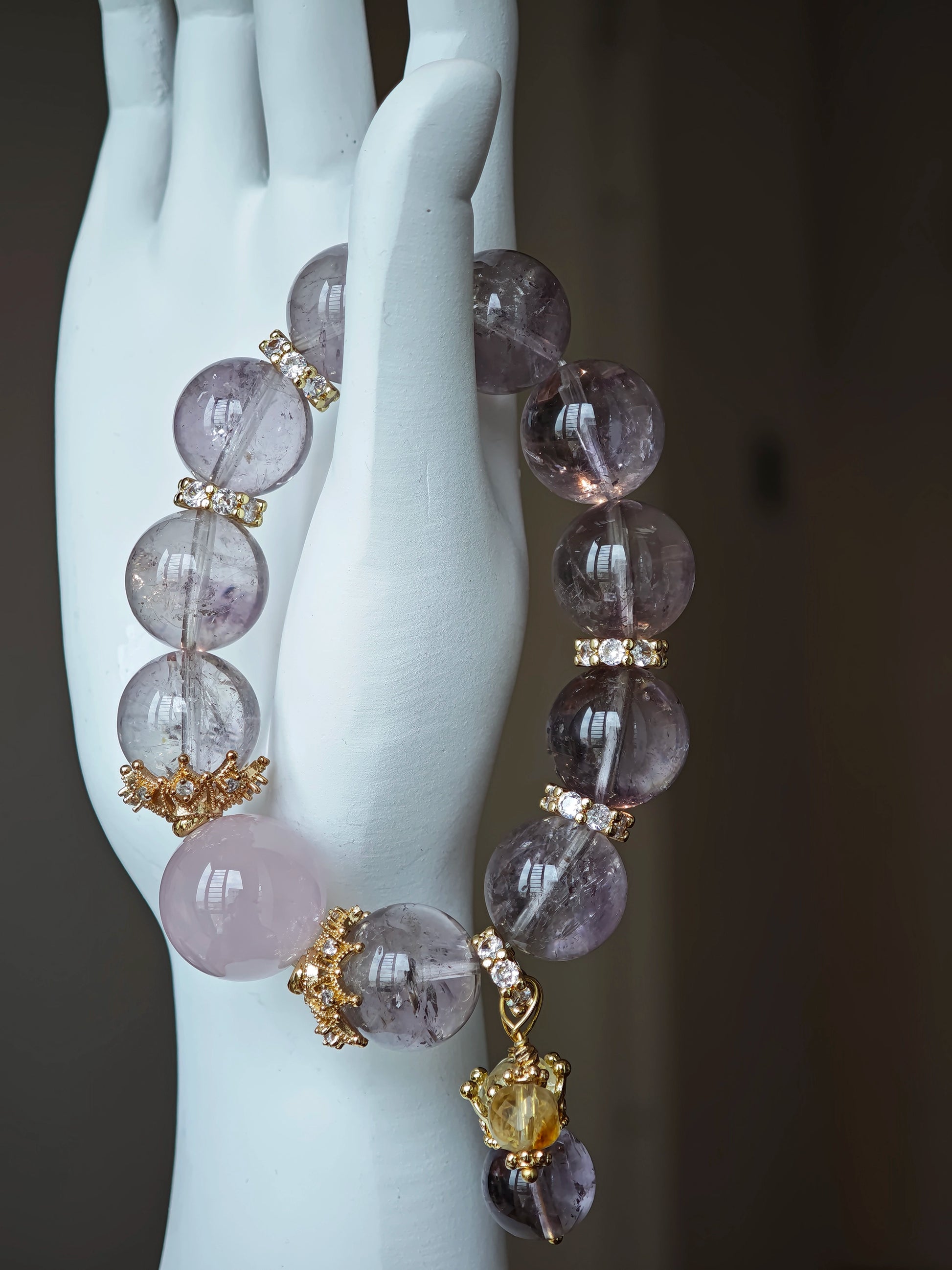 This is a bracelet featuring high-clarity amethyst, rose quartz, and citrine. It's an elegant look of pure peace.