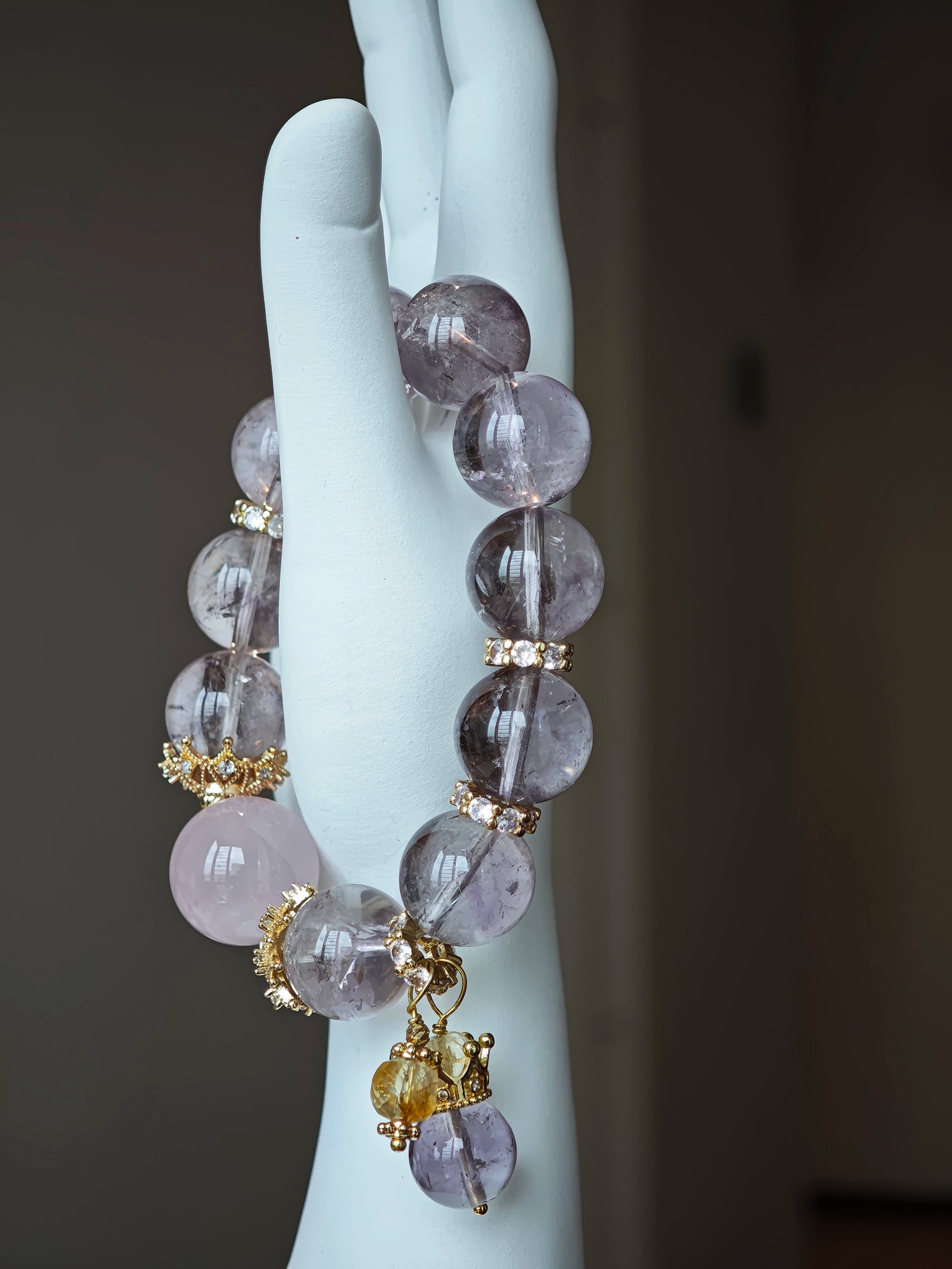 This is a bracelet featuring high-clarity amethyst, rose quartz, and citrine. It's an elegant look of pure peace.