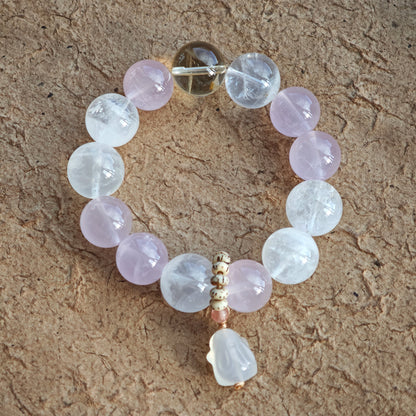 A delicate crystal bracelet of Rose Quartz, White Phantom Quartz, and an agate rabbit slider charm.