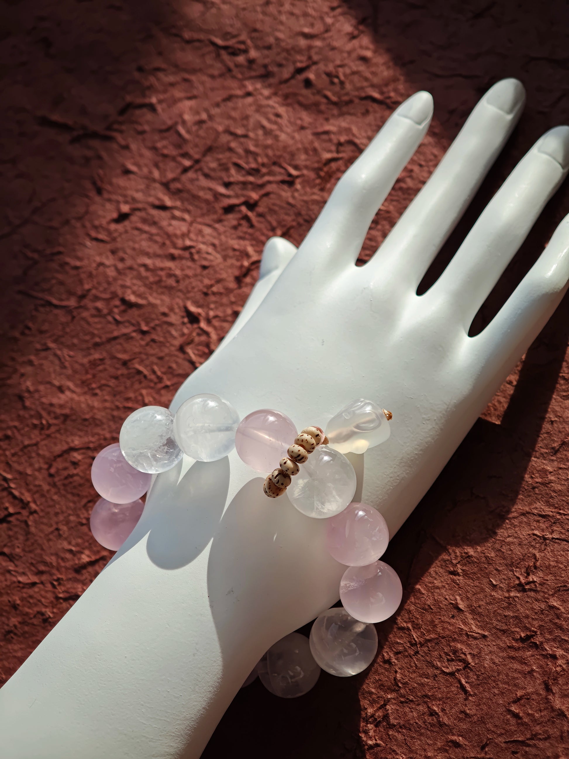 This crystal band pairs Rose Quartz with White Phantom Quartz and a hopping agate rabbit accent.