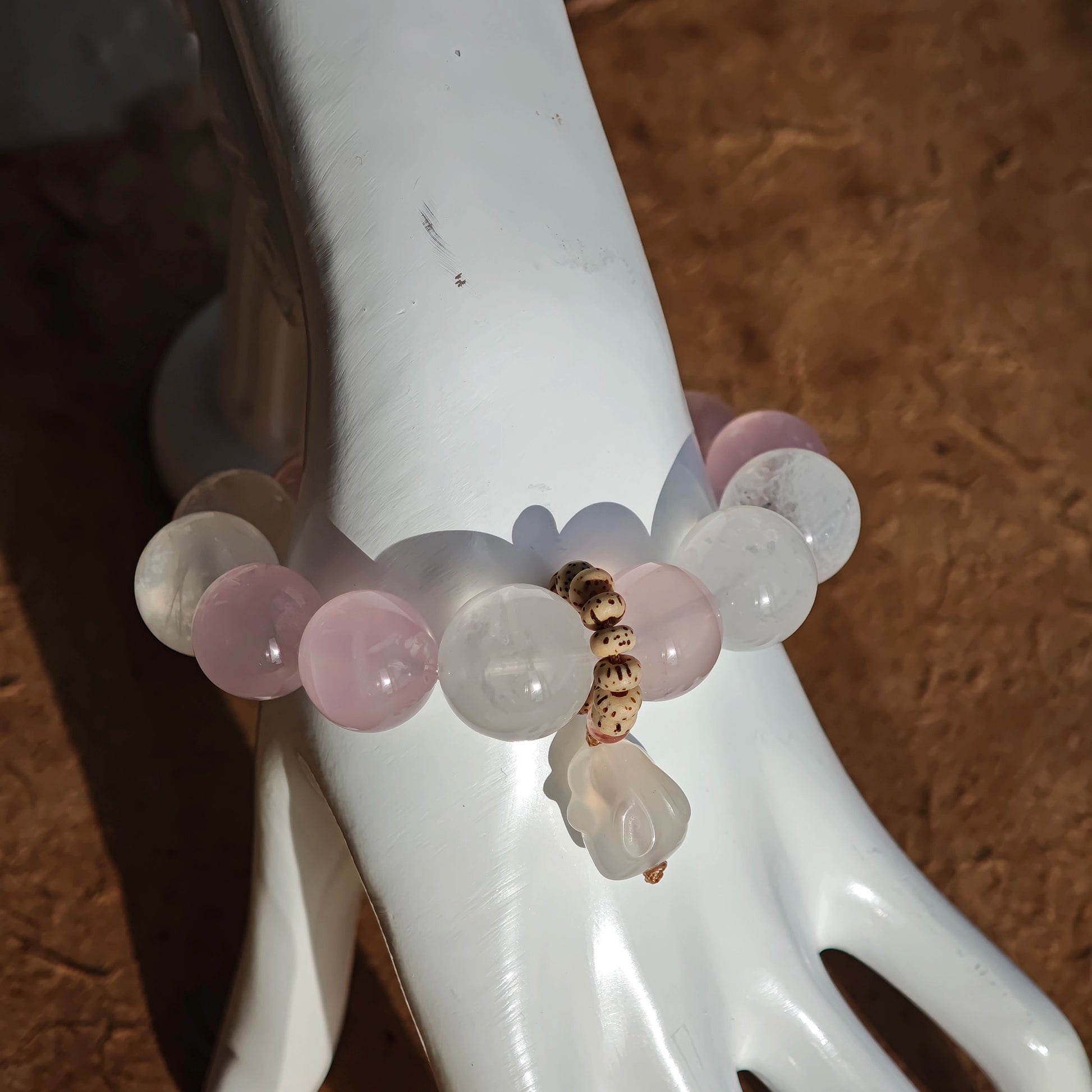 A crystal trio of Rose Quartz, White Phantom Quartz, and an agate rabbit bead forms this bracelet.