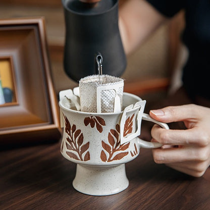 This is a 300ml ceramic goblet mug with hand-painted leaf or flower patterns and a matte sesame-speckled glaze design. With mouth diameter of 9.7, bottom diameter of 6.7cm and height of 10.5cm, this mug is ideal for coffee, milk, water, or oatmeal during slow mornings or quiet afternoons.