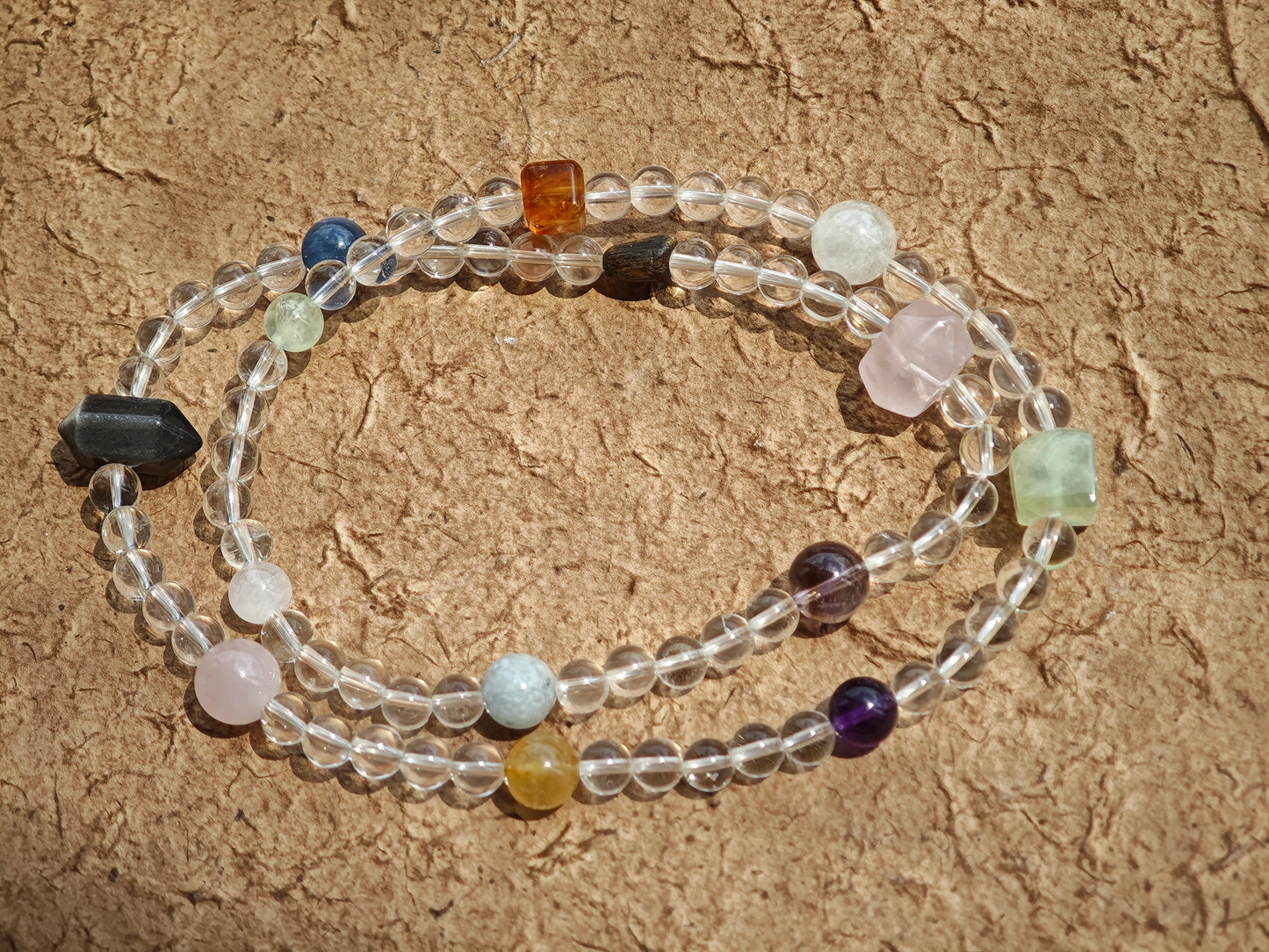 A multi-gemstone bracelet which is made with Silver Sheen Obsidian, Clear Quartz, Amethyst, Rose Quartz, Kyanite, Citrine, and Prehnite, etc. It’s also a necklace.