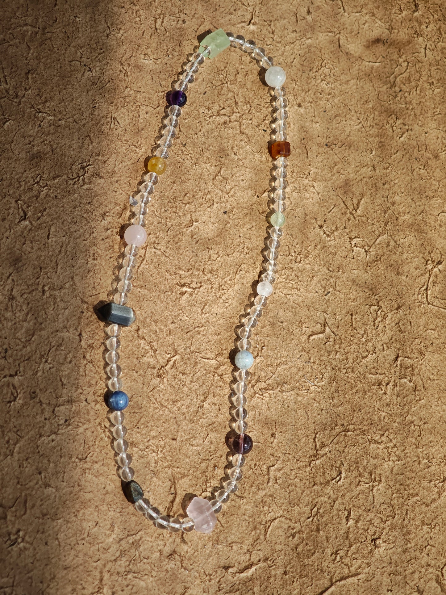 A multi-gemstone bracelet which is made with Silver Sheen Obsidian, Clear Quartz, Amethyst, Rose Quartz, Kyanite, Citrine, and Prehnite, etc. It’s also a necklace.