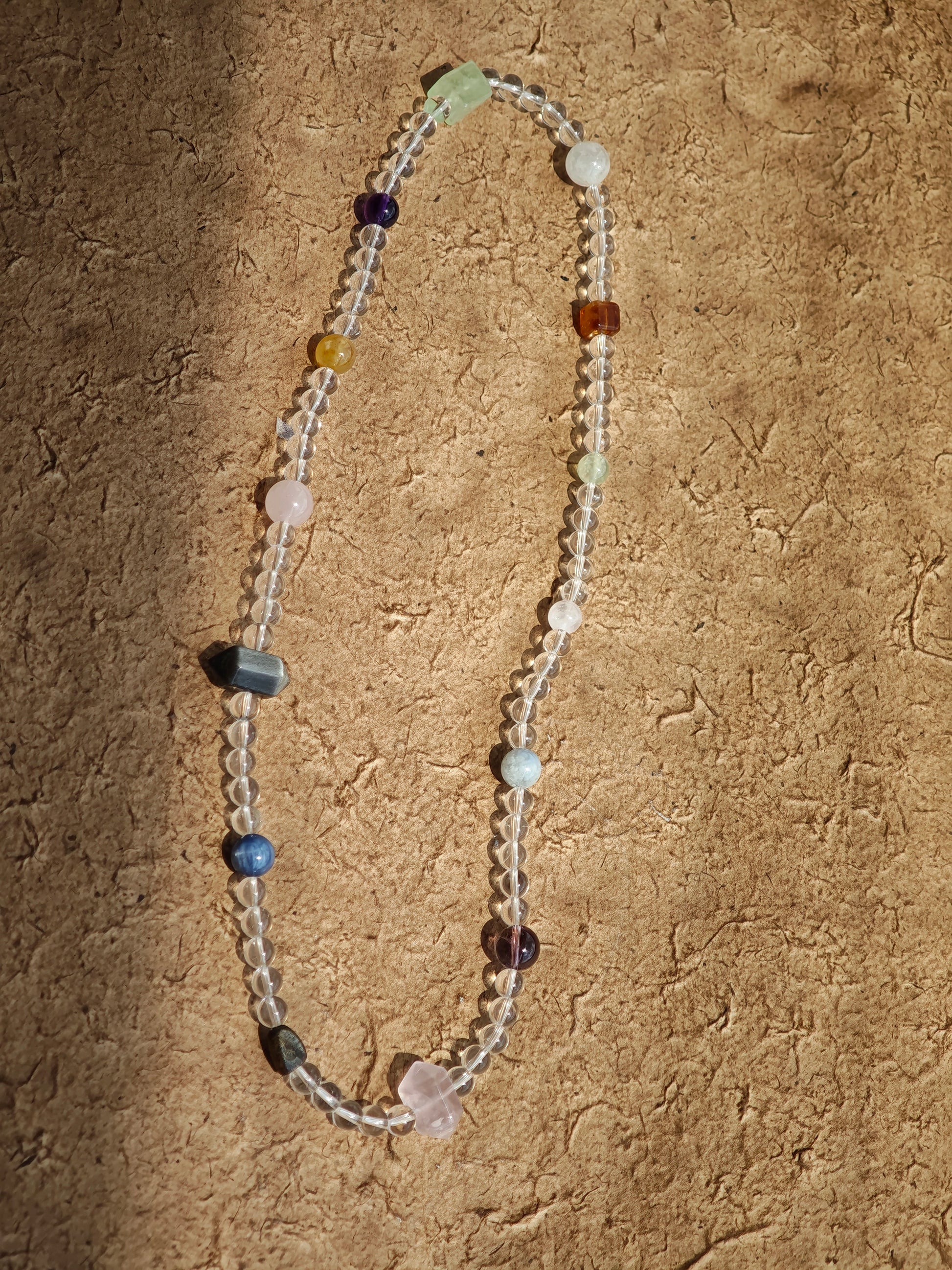 A multi-gemstone bracelet which is made with Silver Sheen Obsidian, Clear Quartz, Amethyst, Rose Quartz, Kyanite, Citrine, and Prehnite, etc. It’s also a necklace.