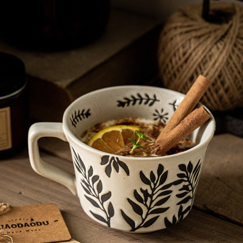 This is a 325ml coarse ceramic mug with a matte sesame-speckled glaze and hand-painted leaf design. It comes with a rounded handle that sits comfortably in your hand. Ideal for coffee, milk, water, or oatmeal during slow mornings or quiet afternoons.