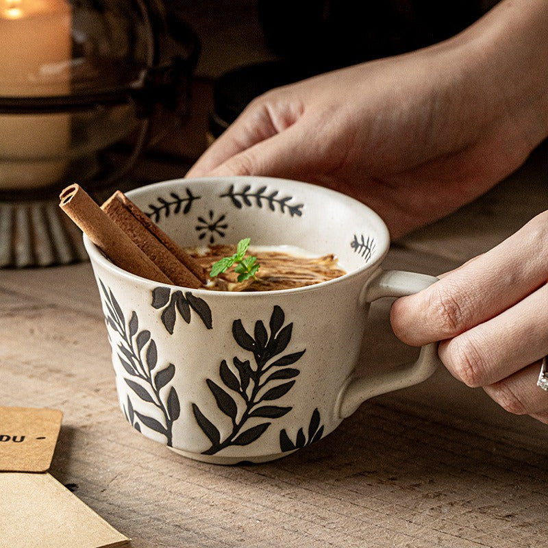 This is a 325ml coarse ceramic mug with a matte sesame-speckled glaze and hand-painted leaf design. It comes with a rounded handle that sits comfortably in your hand. Ideal for coffee, milk, water, or oatmeal during slow mornings or quiet afternoons.