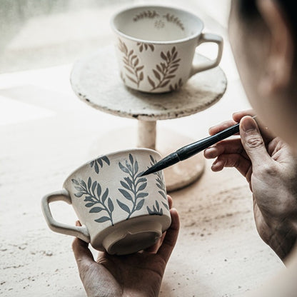 This is a 325ml coarse ceramic mug with a matte sesame-speckled glaze and hand-painted leaf design. It comes with a rounded handle that sits comfortably in your hand. Ideal for coffee, milk, water, or oatmeal during slow mornings or quiet afternoons.