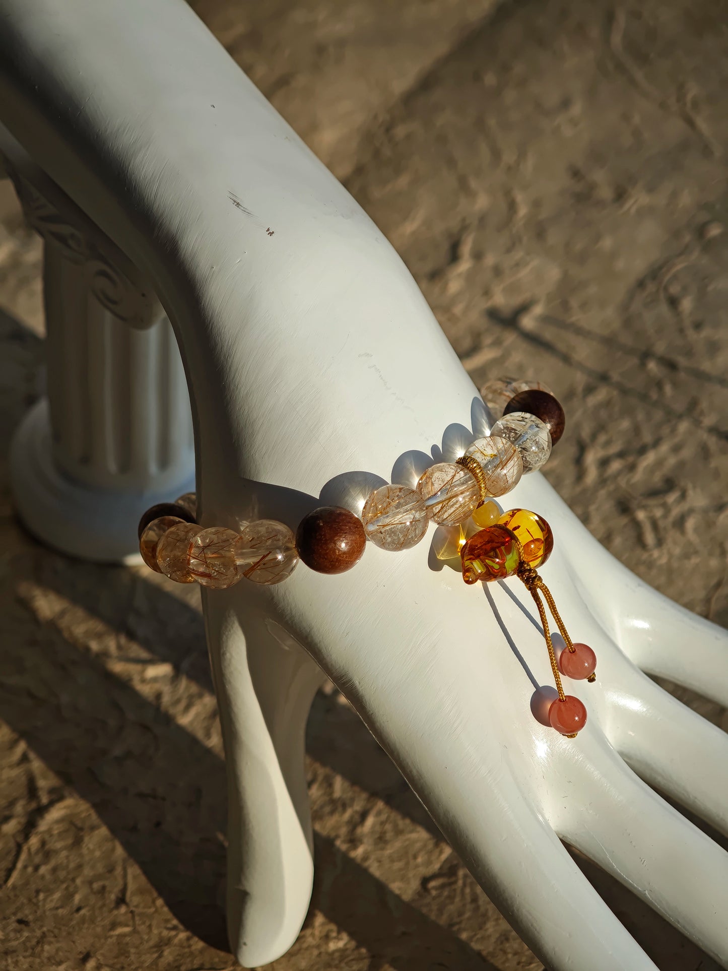 Copper galaxies glitter inside each bead, agarwood whispers mantras, and the floral calabash locks luck in its curl.