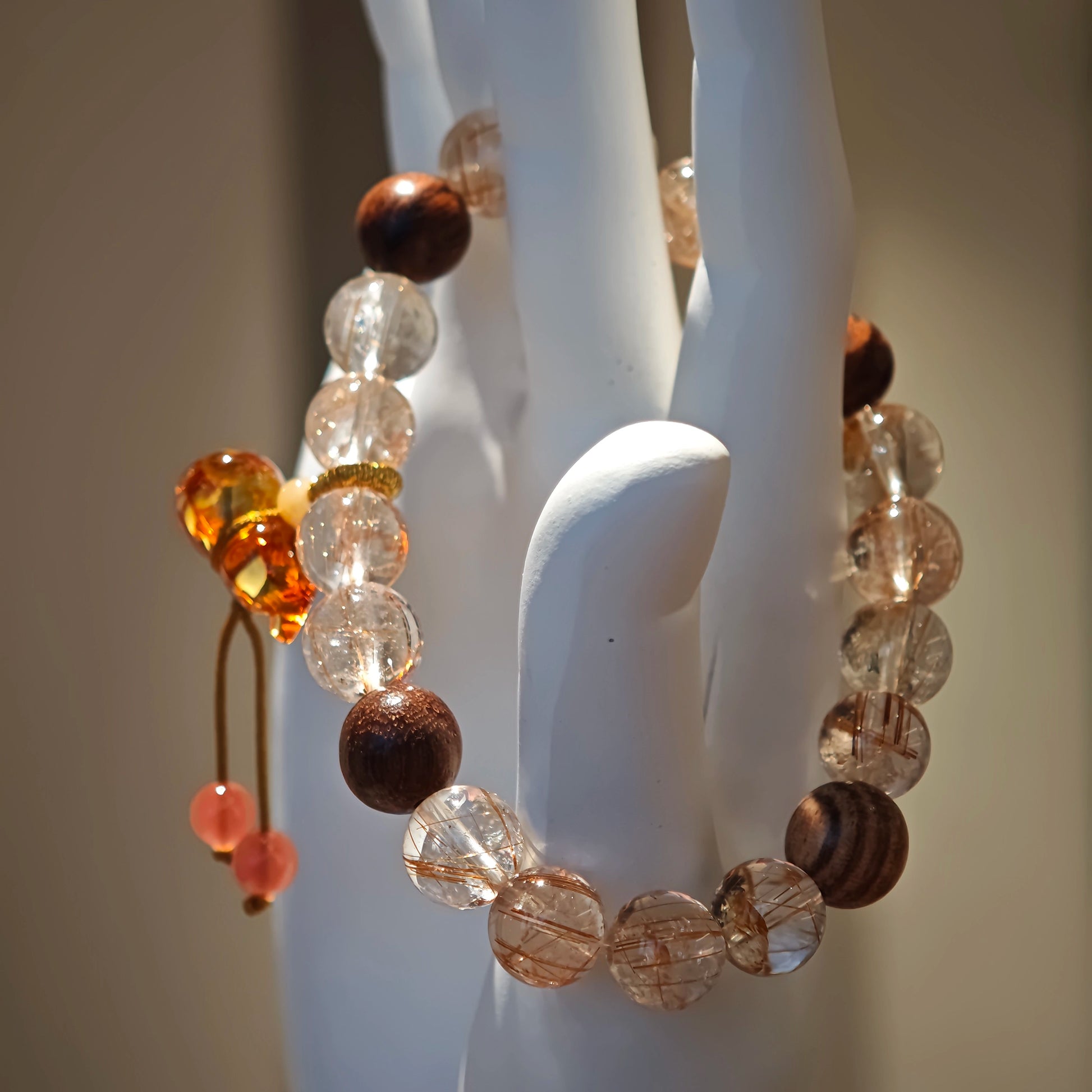 Gleaming copper-red rutile threads embrace earthy agarwood circles, all guarded by a carved amber gourd blooming in Nanhong jade.