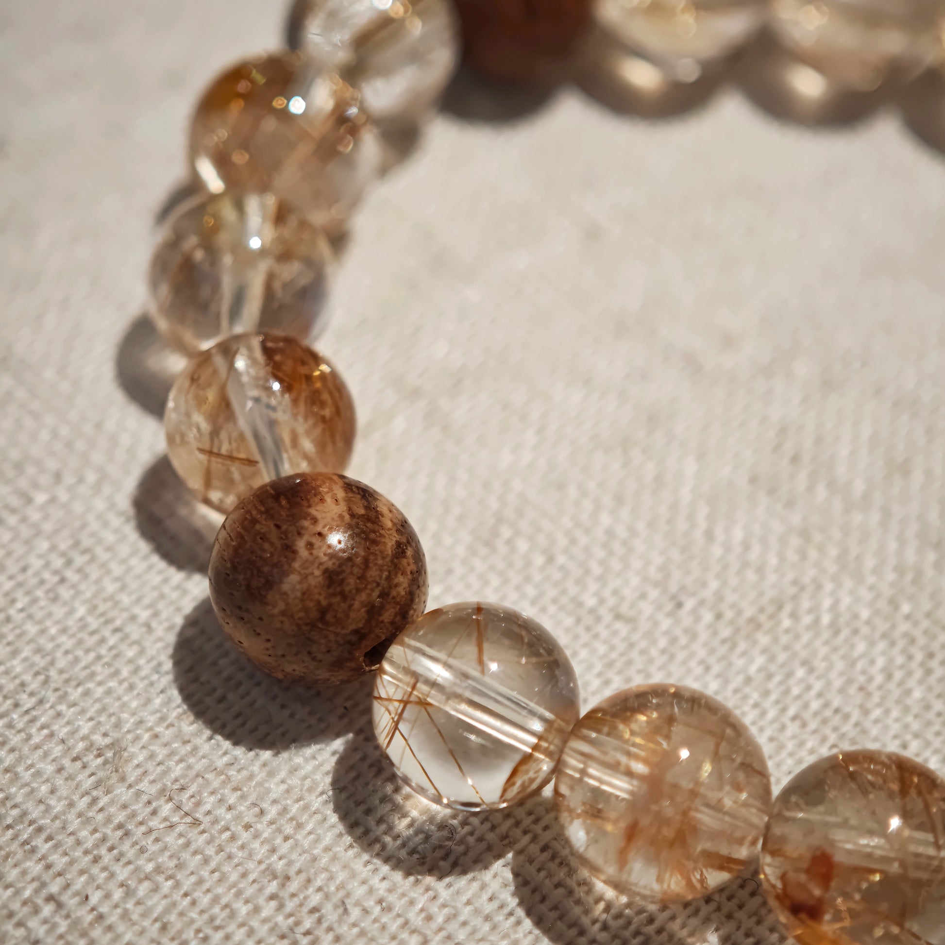 From golden filaments to woody perfume, the strand ends in a scarlet-veined amber calabash—an amulet of wealth and watchfulness.