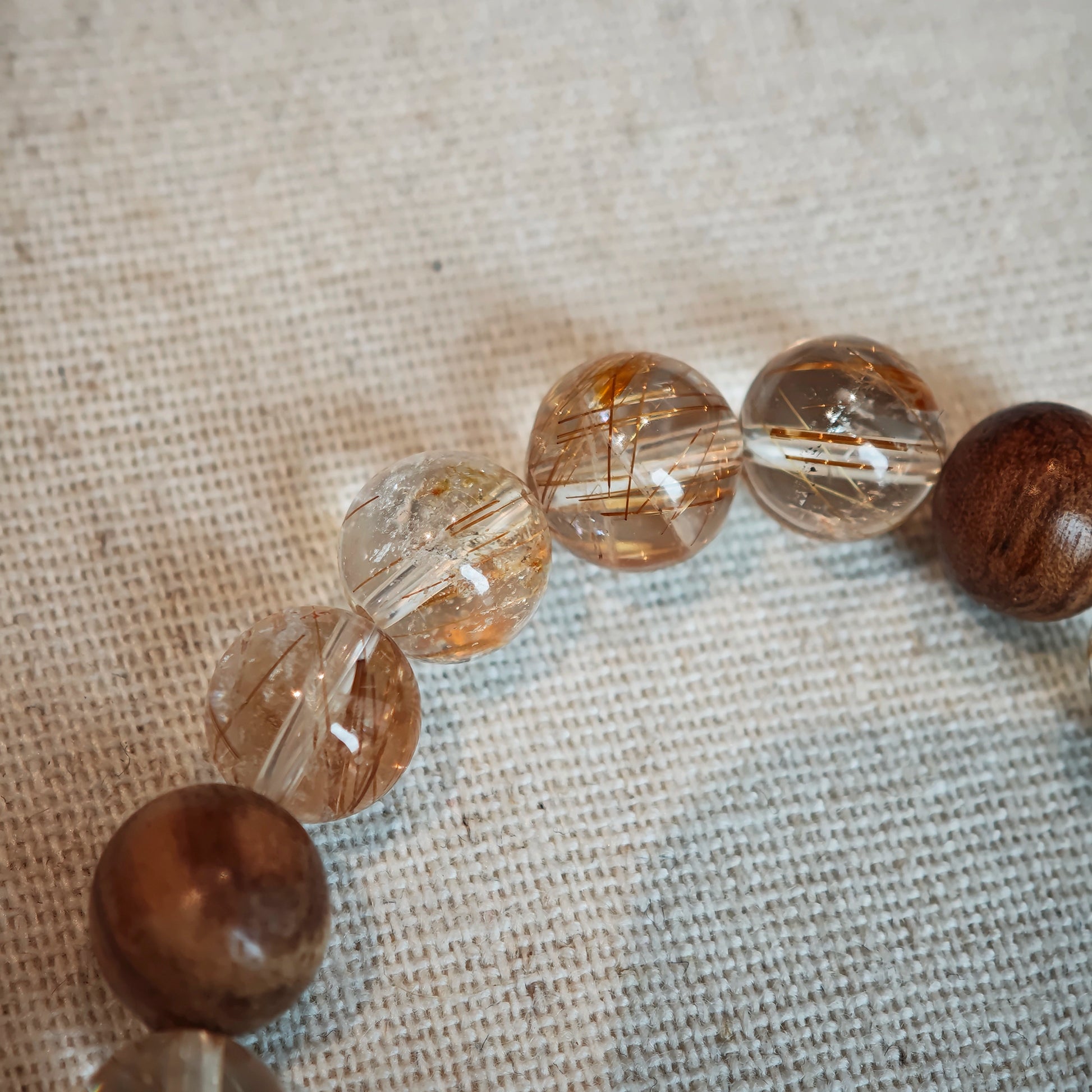 Radiant copper rutile meets meditative agarwood, crowned by a delicate floral gourd carved in South-Red agate, blooming with blessings.