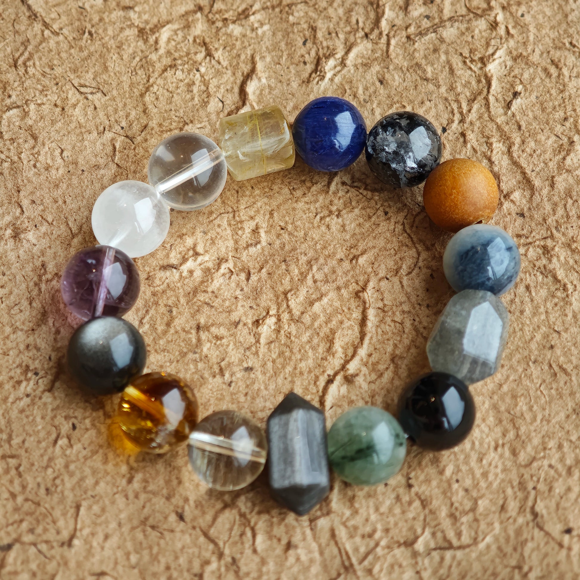 Icy tones meet purple, gold and silver flash in this strand of rutile, phantom, citrine, amethyst, moonstone and obsidian.