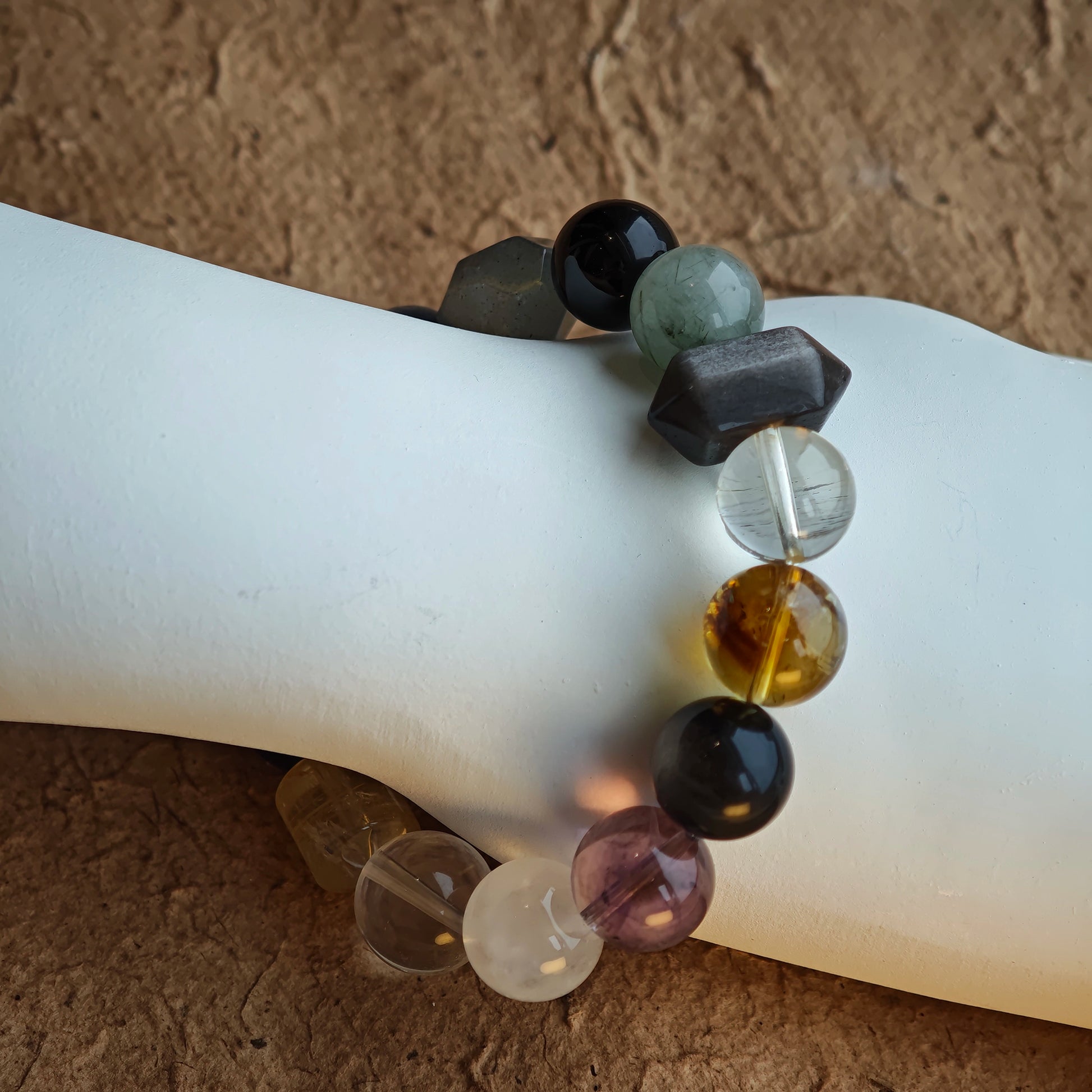 A cool-mystic bracelet blending rutilated quartz, white phantom, citrine, amethyst, moonstone & silver obsidian.