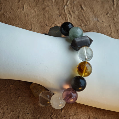 A cool-mystic bracelet blending rutilated quartz, white phantom, citrine, amethyst, moonstone & silver obsidian.