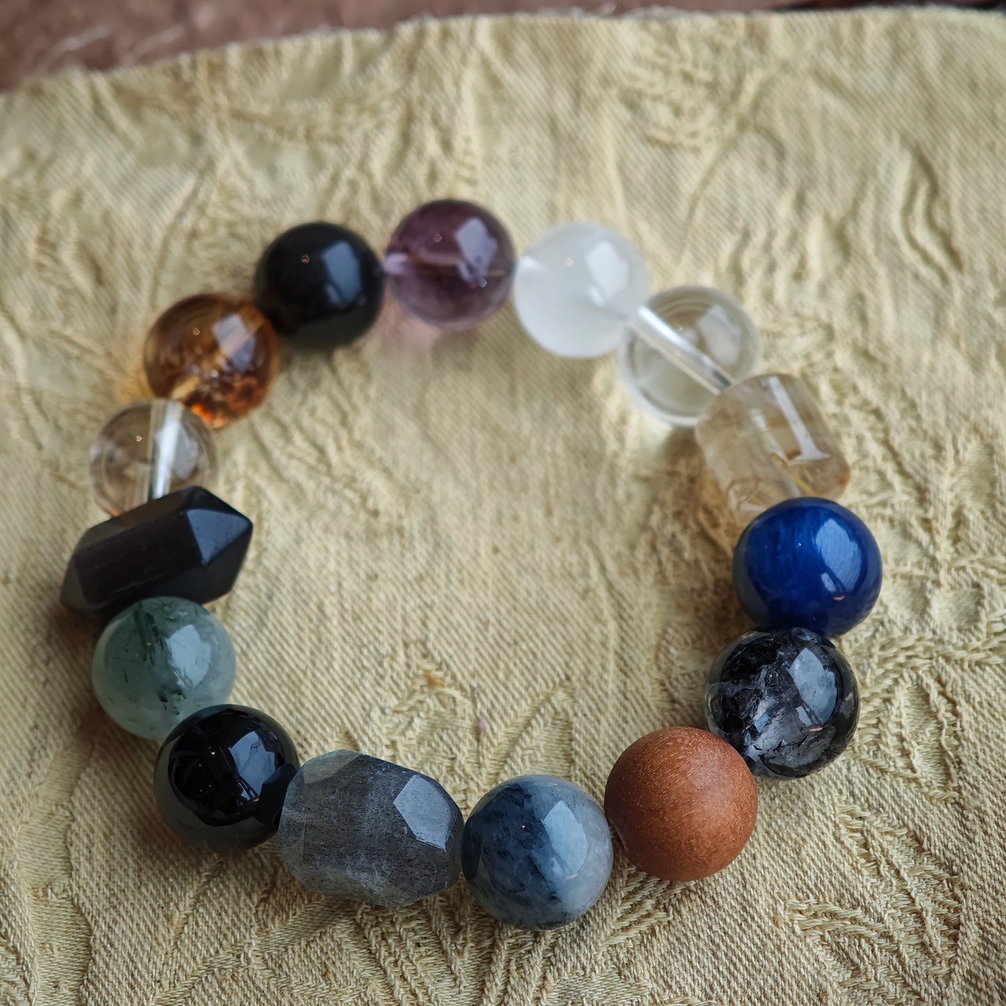 The bracelet pairs cool rutilated quartz, white phantom, citrine, amethyst, moonstone and silver obsidian with any outfit.