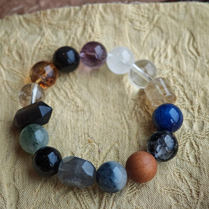 The bracelet pairs cool rutilated quartz, white phantom, citrine, amethyst, moonstone and silver obsidian with any outfit.