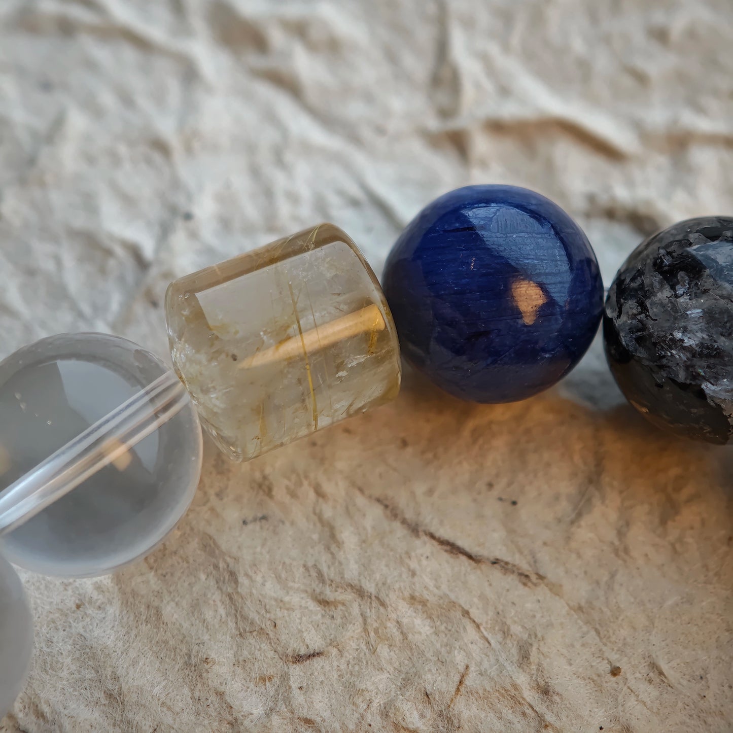 Cool neutrals rule: rutilated quartz, white phantom, citrine, amethyst, moonstone and silver-sheen obsidian side by side.