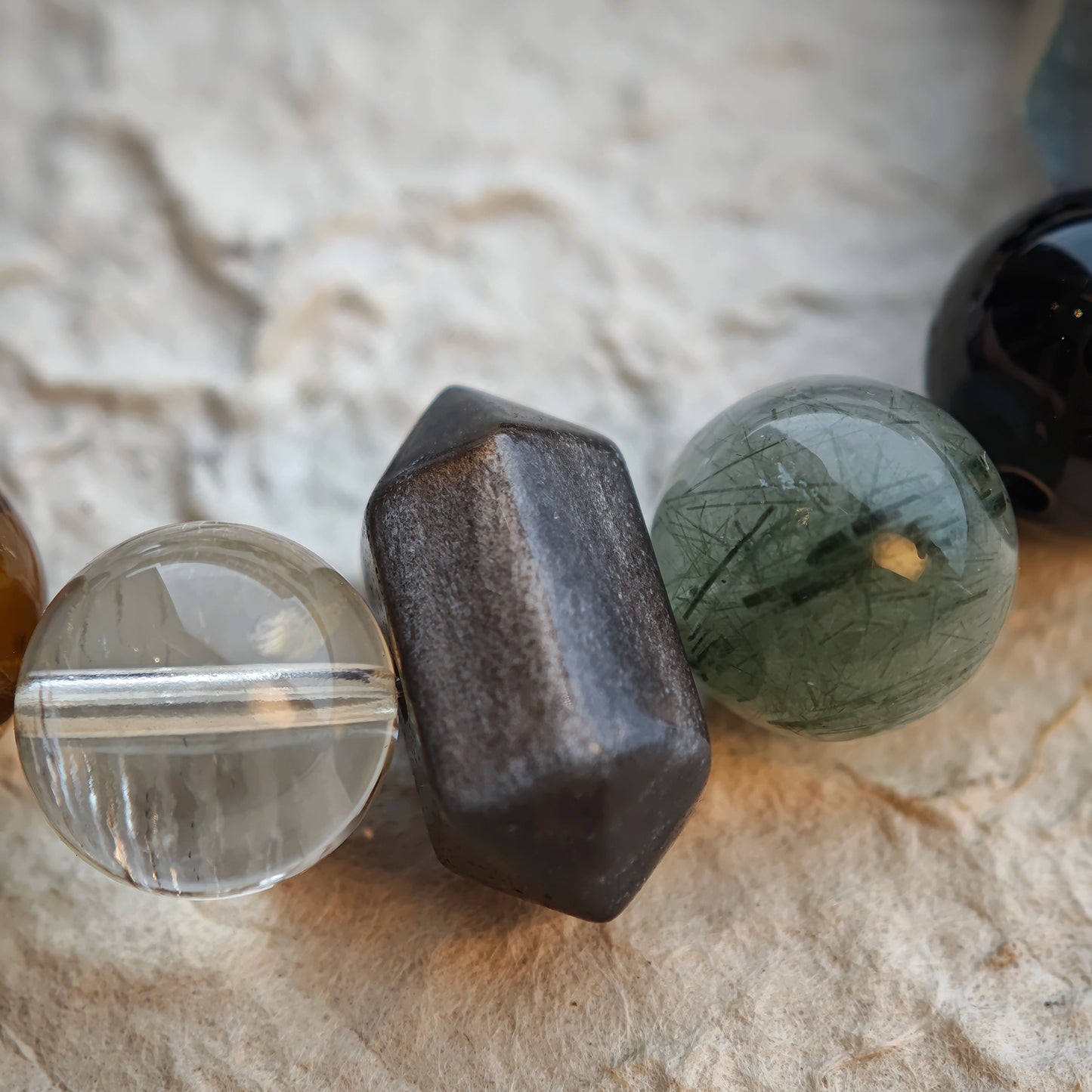 A minimalist crystal mix—rutile, phantom, citrine, amethyst, moonstone, silver obsidian—delivers quiet mystery.