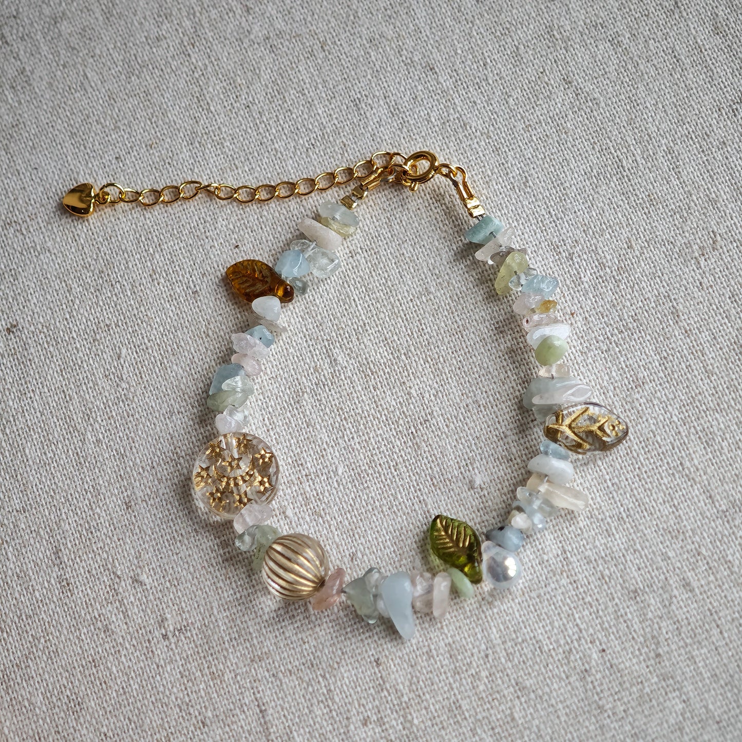Consist of milky white and pale blue glass beads and shimmering crystal fragments, this beaded bracelet glows like sunlight dancing on icy shores.