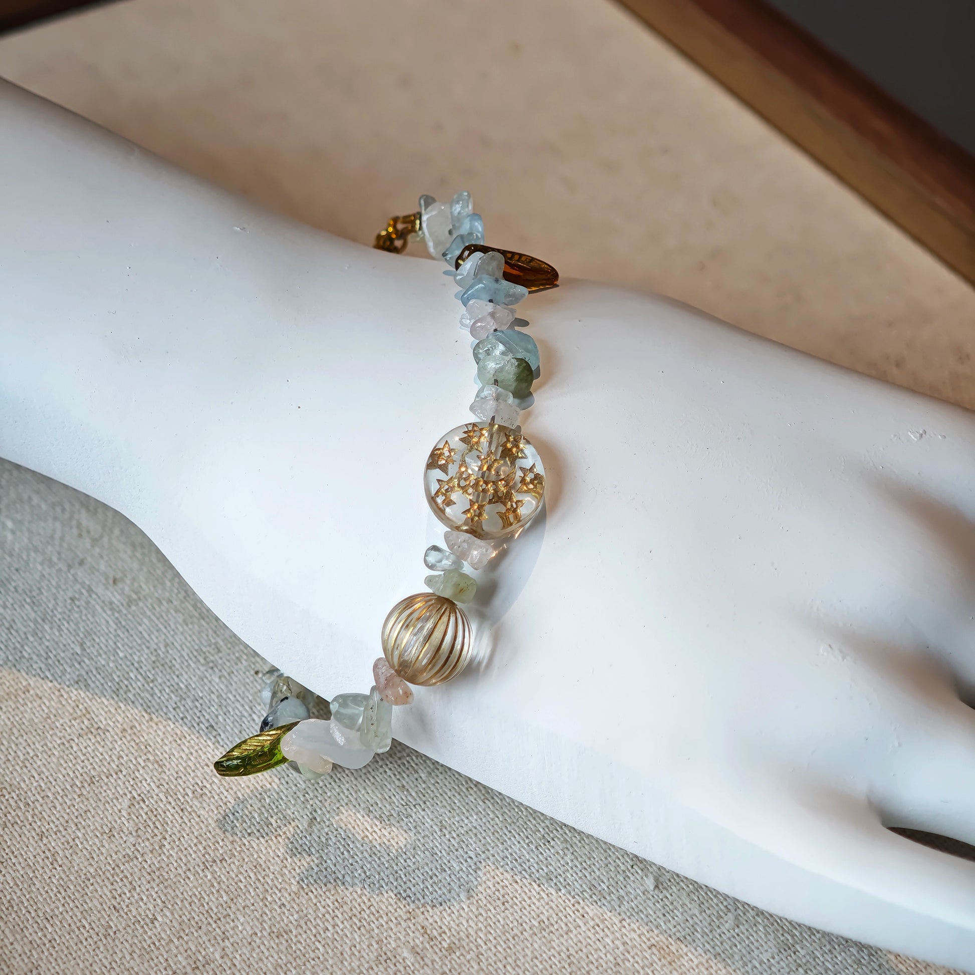 Consist of milky white and pale blue glass beads and shimmering crystal fragments, this beaded bracelet glows like sunlight dancing on icy shores.