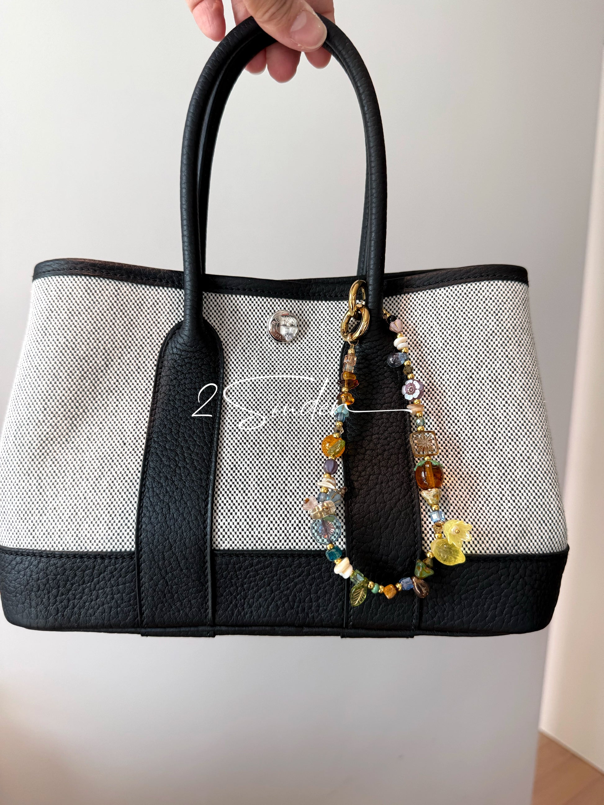 This is a bag charm that made of Czech beads. In the phone strap, there are different spacers like orange, leaves, flowers and lemon. It's with multi colors. This bag charm can also be used as a phone strap and key chain.