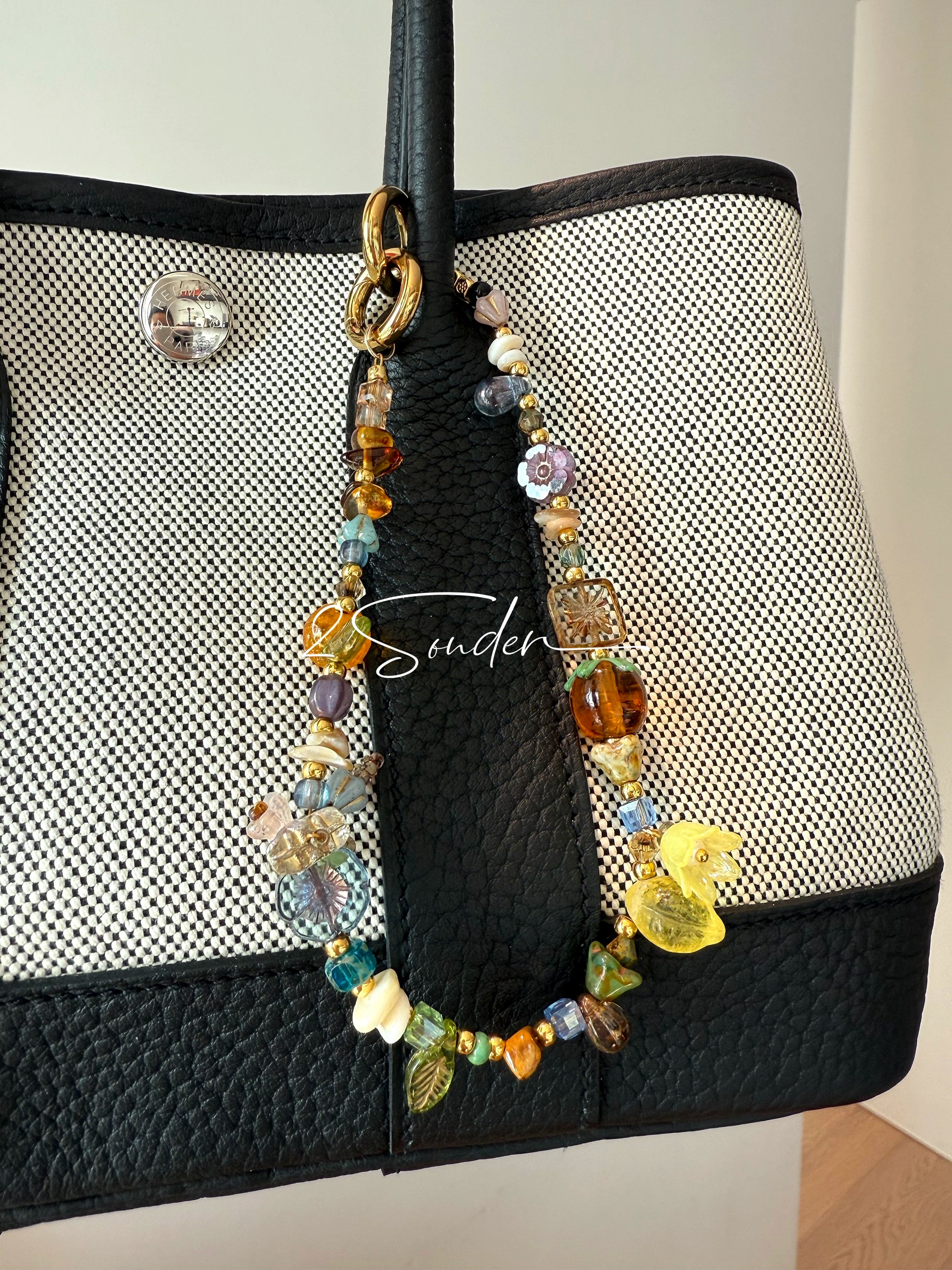 This is a bag charm that made of Czech beads. In the phone strap, there are different spacers like orange, leaves, flowers and lemon. It's with multi colors. This bag charm can also be used as a phone strap and key chain.