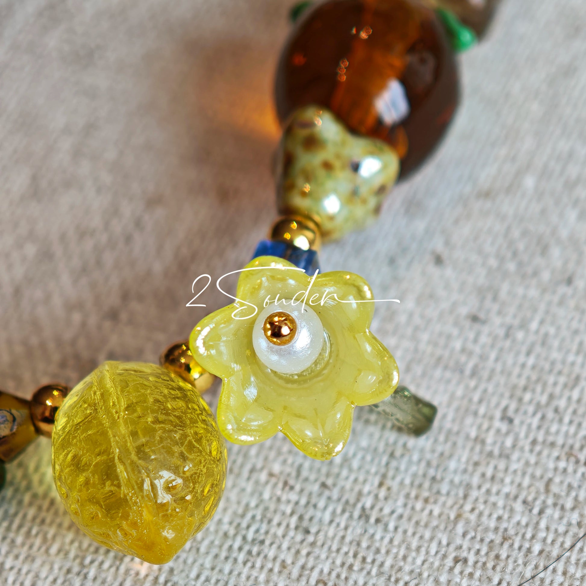 This is a bag charm that made of Czech beads. In the phone strap, there are different spacers like orange, leaves, flowers and lemon. It's with multi colors. This bag charm can also be used as a phone strap and key chain.