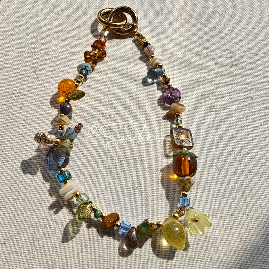 This is a bag charm that made of Czech beads. In the phone strap, there are different spacers like orange, leaves, flowers and lemon. It's with multi colors. This bag charm can also be used as a phone strap and key chain.