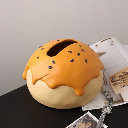 This is tissue box cover with an egg yolk pastry shape. On the lifelike flaky pstry surface, there are sesame seeds and a wide enough opening for pulling out tissues.