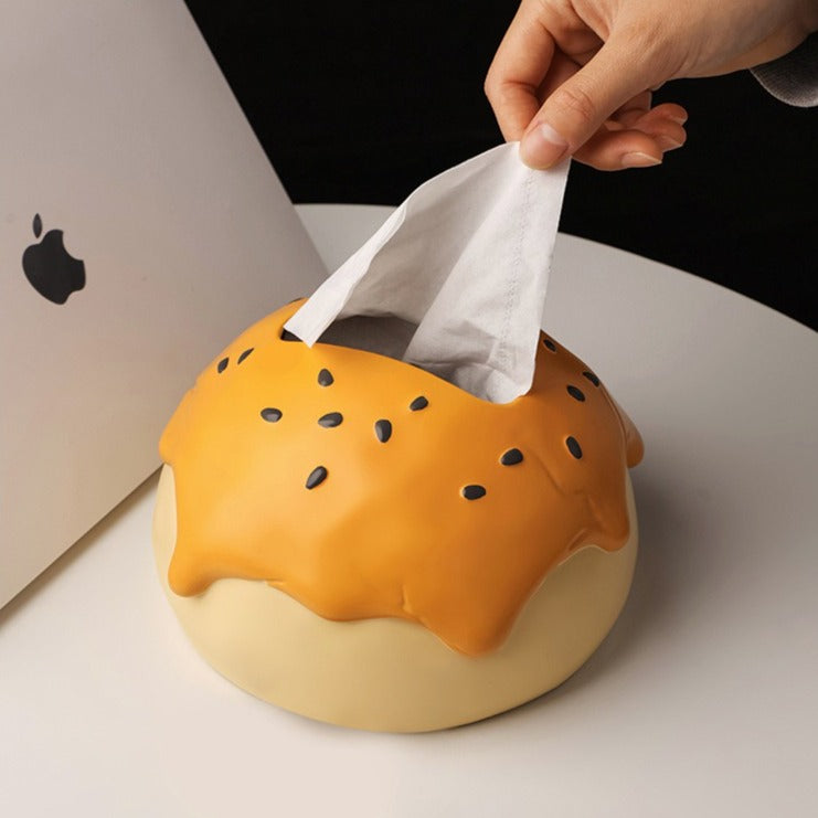 This is tissue box cover with an egg yolk pastry shape. On the lifelike flaky pstry surface, there are sesame seeds and a wide enough opening for pulling out tissues.