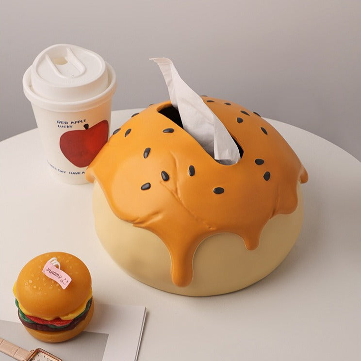 This is tissue box cover with an egg yolk pastry shape. On the lifelike flaky pstry surface, there are sesame seeds and a wide enough opening for pulling out tissues.