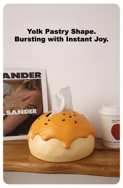This is tissue box cover with an egg yolk pastry shape. On the lifelike flaky pstry surface, there are sesame seeds and a wide enough opening for pulling out tissues.