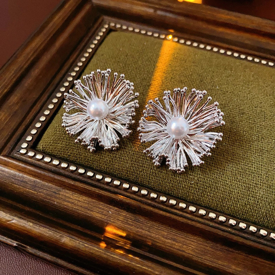 These earrings perfectly blend delicate flowers with lustrous pearls, exuding timeless romance and adding an elegant touch to any outfit.