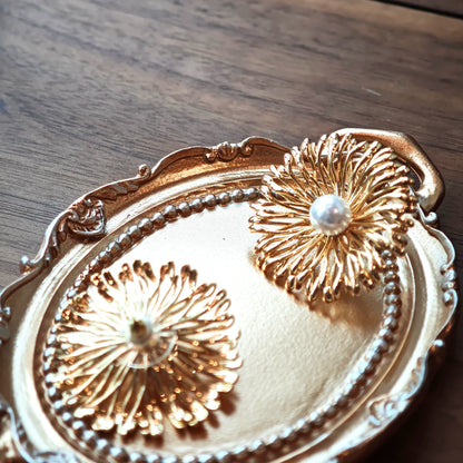 These earrings perfectly blend delicate flowers with lustrous pearls, exuding timeless romance and adding an elegant touch to any outfit.