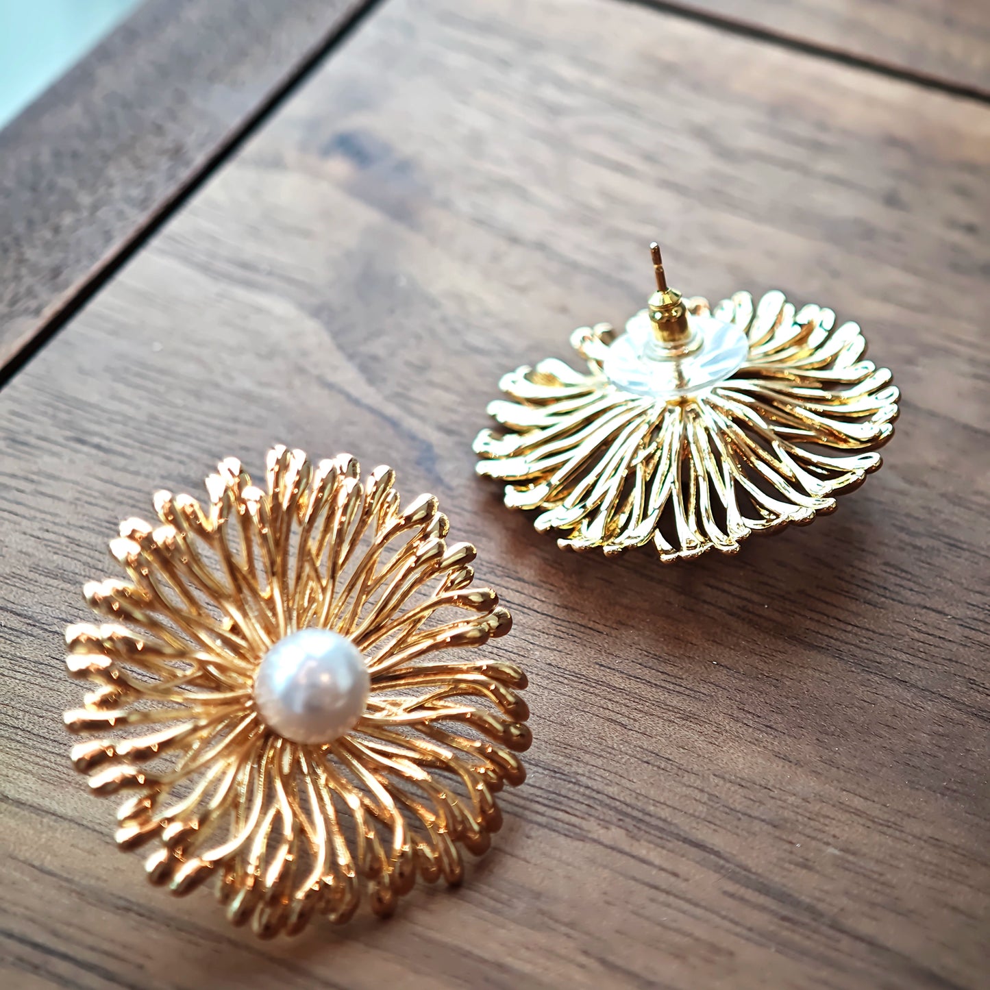 These earrings perfectly blend delicate flowers with lustrous pearls, exuding timeless romance and adding an elegant touch to any outfit.