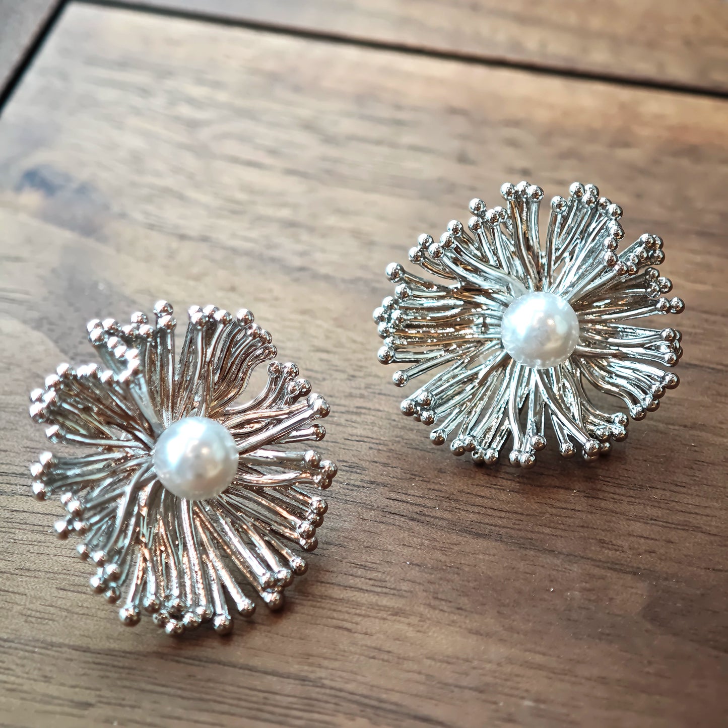 These earrings perfectly blend delicate flowers with lustrous pearls, exuding timeless romance and adding an elegant touch to any outfit.