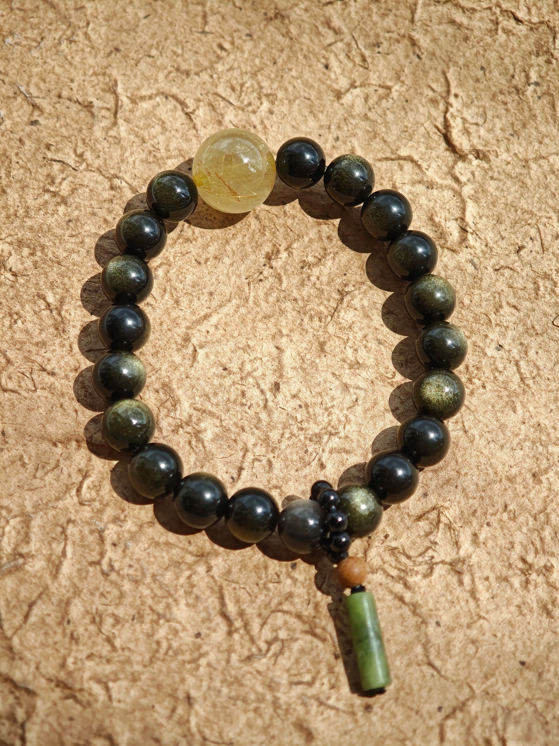 Simple obsidian rounds, radiant rutile, and a sandalwood-agate pendant echo Chinese heritage.